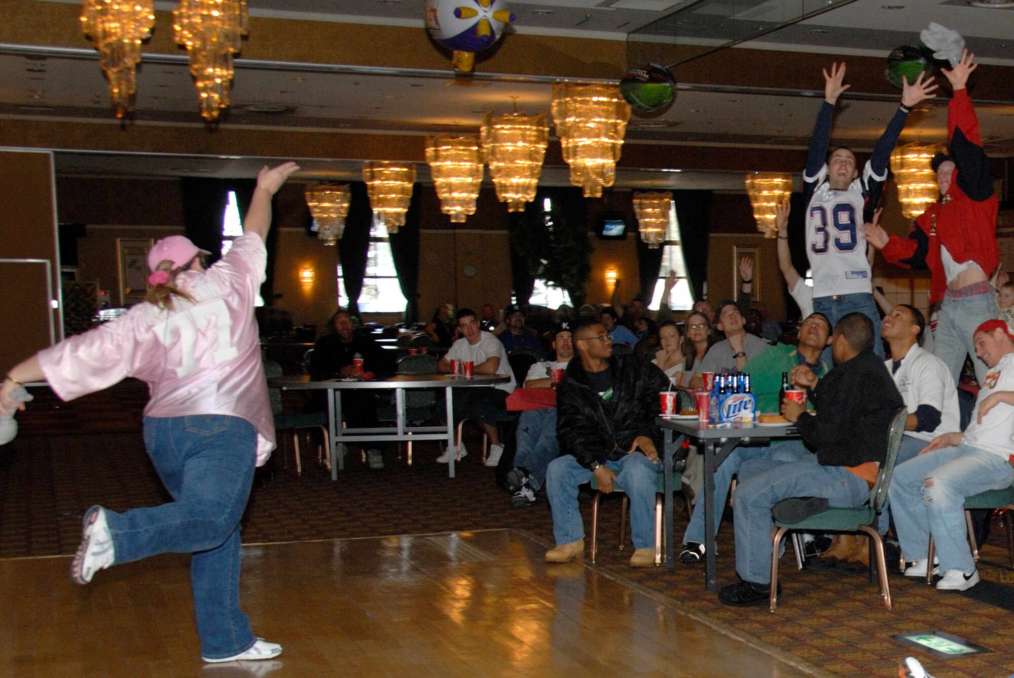 MISAWA AIR BASE, Japan -- Airman 1st Class Kevin Carroll (right), and Airman Daniel Knowlton (middle), both 35th Civil Engineer Squadron members, jump for a t-shirt tossed by Erin Robinson, Area Talent Coordinator for Night Life Entertainment here, Feb. 4, 2008.  Dozens of prizes were given away thoughout the Superbowl celebration at the Tohoku Enlisted Club.  (U.S. Air Force photo by Senior Airman Laura R. McFarlane)