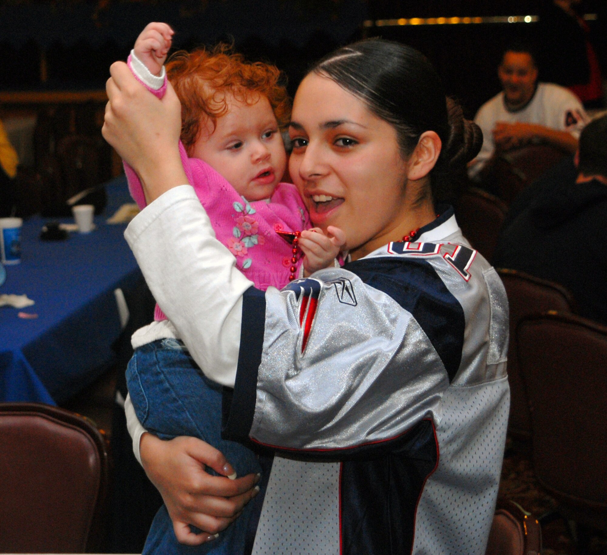 Airman 1st Class April Martinez, 18th Security Forces, and her daughter, Maya, cheer on the New England Patriots during Super Bowl XLII Feb. 4.  The 18th Services Squadron held a number of parties around Kadena for the community to be able to enjoy the big game. 