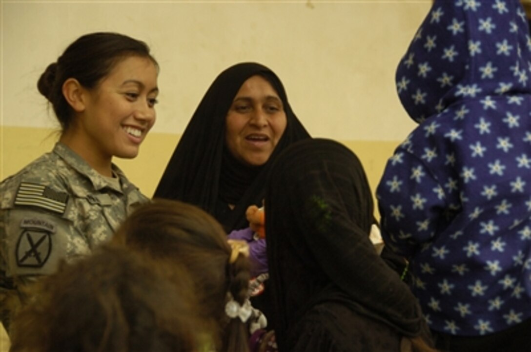 U.S. Army Sgt. Jennifer Manzo (left) of Charlie Company, 94th Brigade Support Battalion, 4th Brigade Combat Team, 10th Mountain Division gives toys to Iraqi children receiving treatment at a medical clinic near Forward Operating Base Rustamiyah in Baghdad, Iraq on Jan. 26, 2008.  