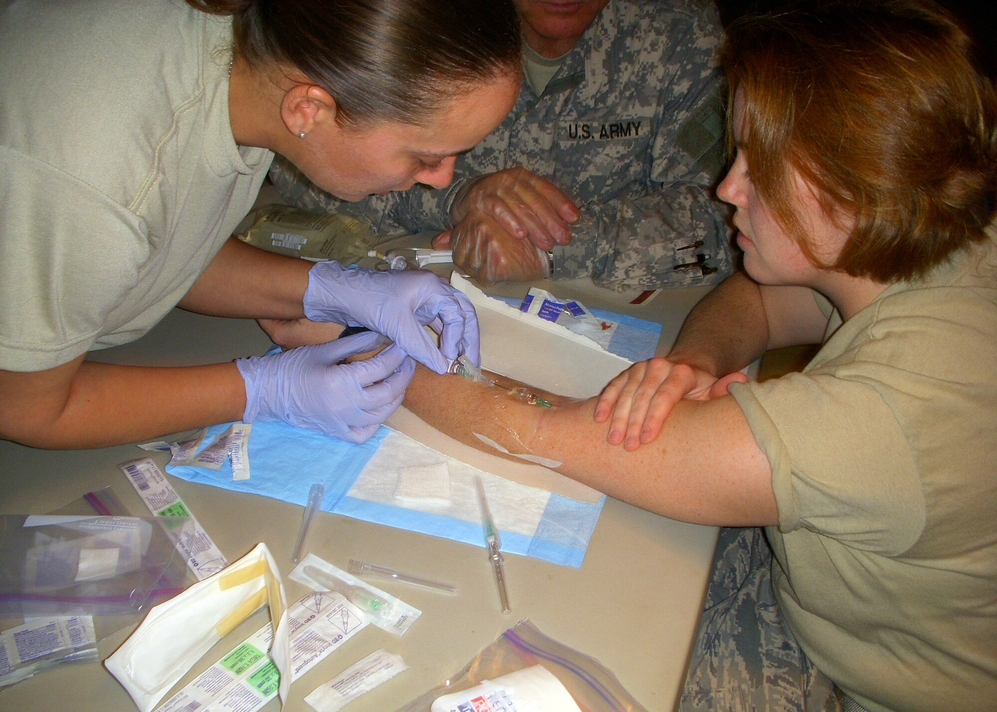 Staff Sgt. Marla Franklin performs a saline lock, more commonly known as an IV, on teammate Staff Sgt. Kacy Harvey during the Combat Lifesavers Course at Forward Operating Base Patriot on Fort Bragg, N.C. Sergeant Franklin deployed from Peterson Air Force Base, Colo., and Sergeant Harvey from Nellis AFB, Nev. The two will forward deploy as members of Provincial Reconstruction Team Gardez near the Pakistan border in Paktya Province, Afghanistan. (U.S. Air Force photo/Staff Sgt. Damien Moody)