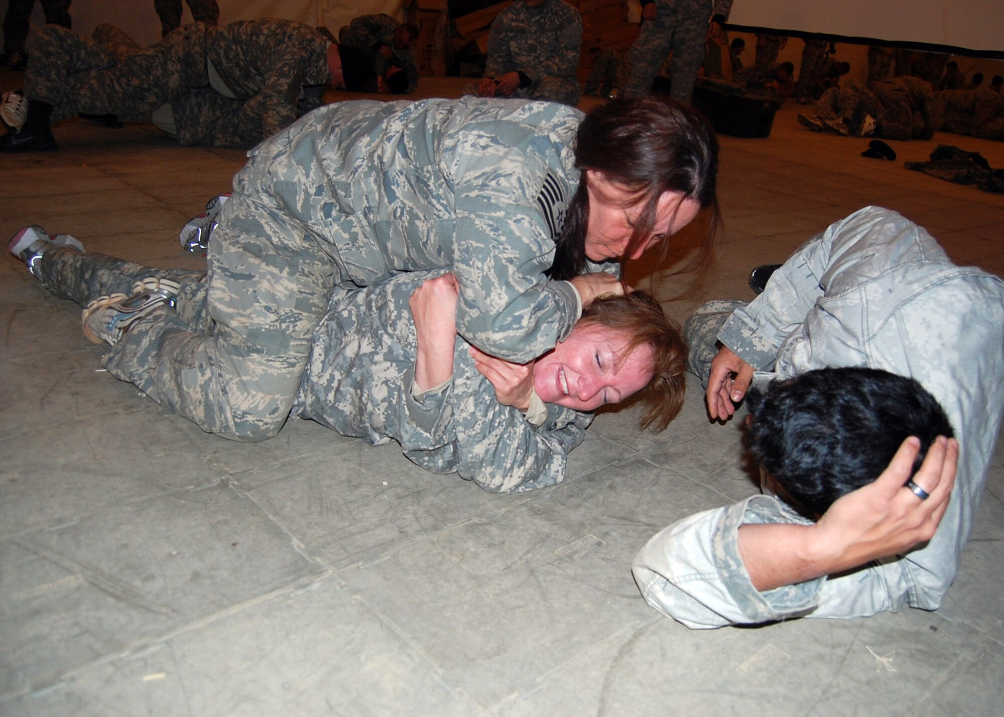 Tech. Sgt. Hattie Douglas, AFROTC Detachment 030 (University of Arkansas), executes a rear-mounted choke on Army Staff Sgt. Jalayna Lagomarsino during Combatives training at FOB Patriot on Fort Bragg, N.C. Given the potential for combat during their daily outside-the-wire missions in Afghanistan, the Airmen and Soldiers of Provincial Reconstruction Team Gardez are being trained to take care of themselves regardless of the situations they may encounter. Hand-to-hand combat is likely the downiest and dirtiest wartime possibility, but one that cannot be overlooked in training. (U.S. Air Force photo/Capt. Ken Hall)