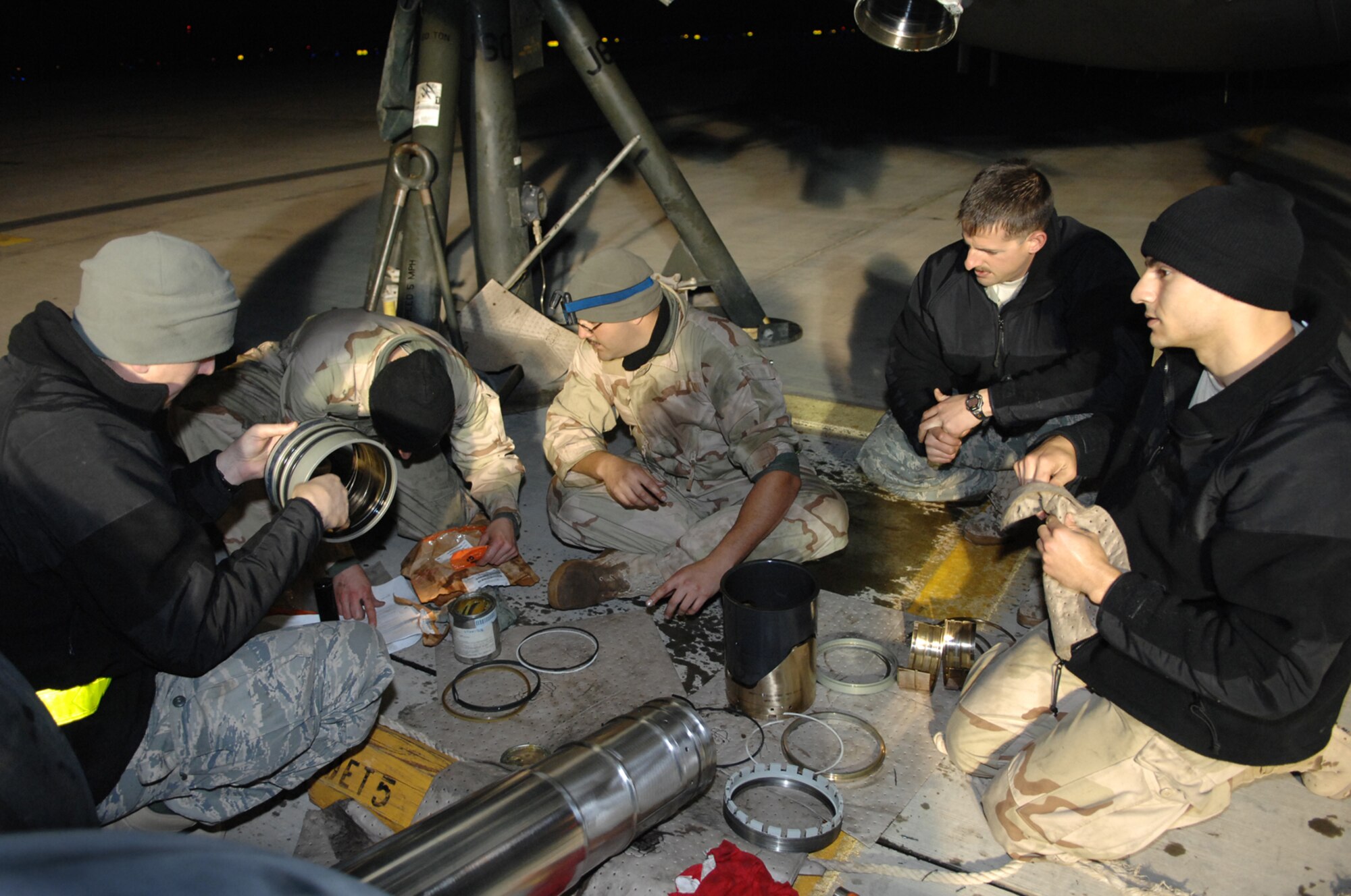 BALAD AIR BASE, Iraq -- Crew chiefs from the 721st Air Mobility Maintenance Group Detachment 5, clean the rings on the nose landing gear assembly strut of a C-17 before re-installing, Feb. 8. The rolled and exposed seal, found earlier that day on the assembly, could cause decompression of the hydraulic fluid resulting in nose damage or penetration of the cockpit. (U.S. Air Force photo/ Senior Airman Julianne Showalter)