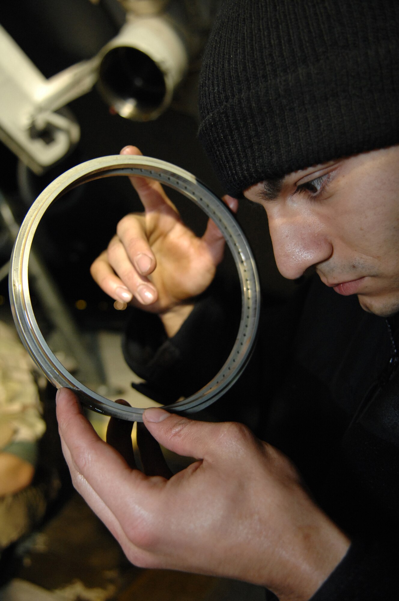 BALAD AIR BASE, Iraq -- Airman 1st Class Richard Garner, 721st Air Mobility Maintenance Group Detachment 5 crew chief, examines one of the rings in the nose landing gear assembly of a C-17 here, Feb. 8. Before re-assembling, all epoxy and hydraulic fluid must be removed for a perfect fit. Carrier aircraft transported 168,324 tons of cargo during here during 2007. Airman Garner is deployed from Travis Air Force Base, Calif. (U.S. Air Force photo/ Senior Airman Julianne Showalter)