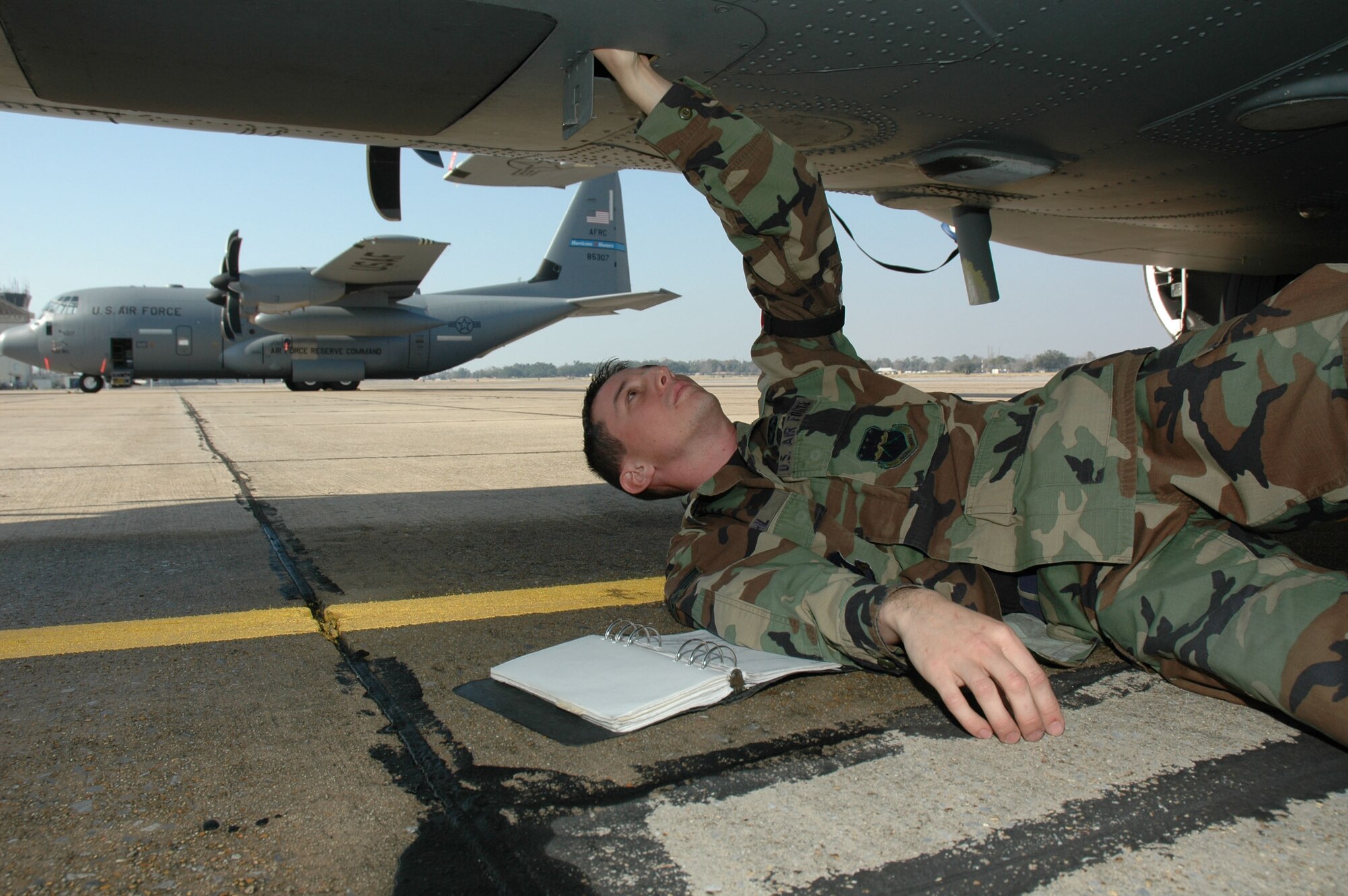 Laying beneathe the belly of the beast, Senior Airman Michael Gehl, a communications/navigation technician with the 403rd Avionics Flight, checks the Doppler velocity sensor on a C-130J during a maintenance  inspection. This type of inspection is conducted after an aircraft leaves the washrack. Other checks after a wash include a corrosion inspection and a function check of the antenna selectors inside the aircraft.