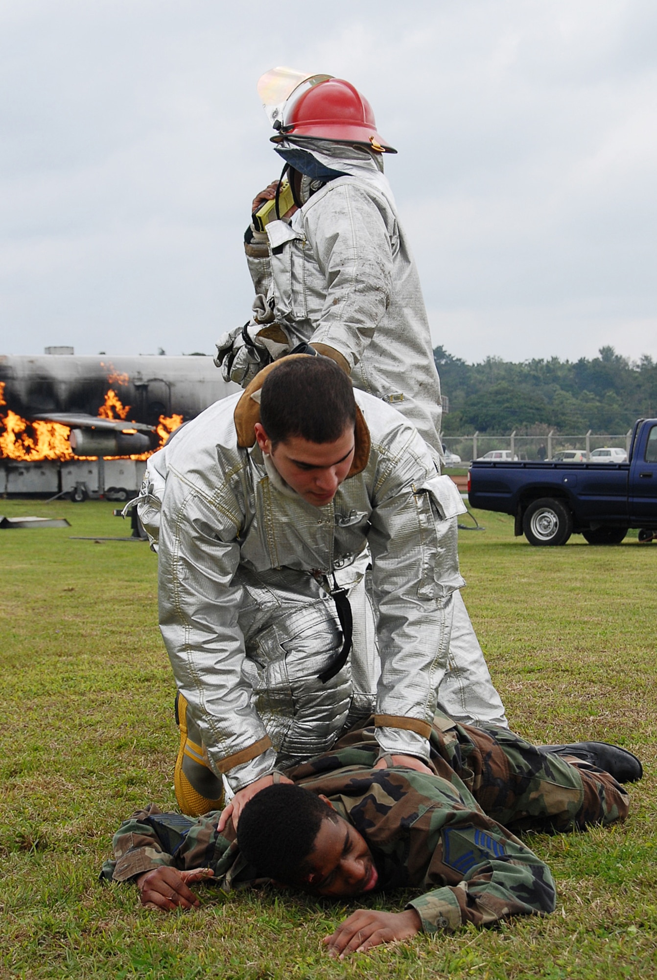 Firefighters from the 18th Civil Engineer Squadron, secure Senior Airman Richard Johns, 18th Equipment Maintenance Squadron, during a Local Operational Readiness Exercise scenario. Airman Johns played a distressed aircrew member in a simulated Kadena-based U.S. Navy P-3 Orion aircraft crash here, Feb. 10, 2008. The 18th Wing conducted Beverly High 08-4 from Feb. 10 to 15 to test Airmen's ability to respond in contingency situations. (U.S. Air Force photo/Tech. Sgt. Anthony Iusi) 