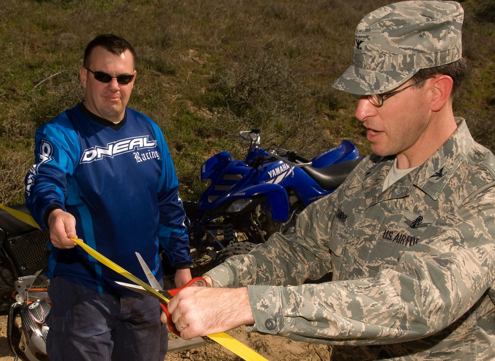 VANDENBERG AIR FORCE BASE, Calif. -- Col. Steve Tanous, 30th Space Wing commander, cuts a ribbon held by Master Sgt. Russell Hanson to declare the grand opening of the off-highway vehicle course Feb. 8. The initial course is approximately five miles long, but future additions will open more 30 miles of trails. Individuals interested in utilizing the course must take a safety class and meet vehicle requirements. (U.S. Air Force photo by Airman 1st Class Christian Thomas)