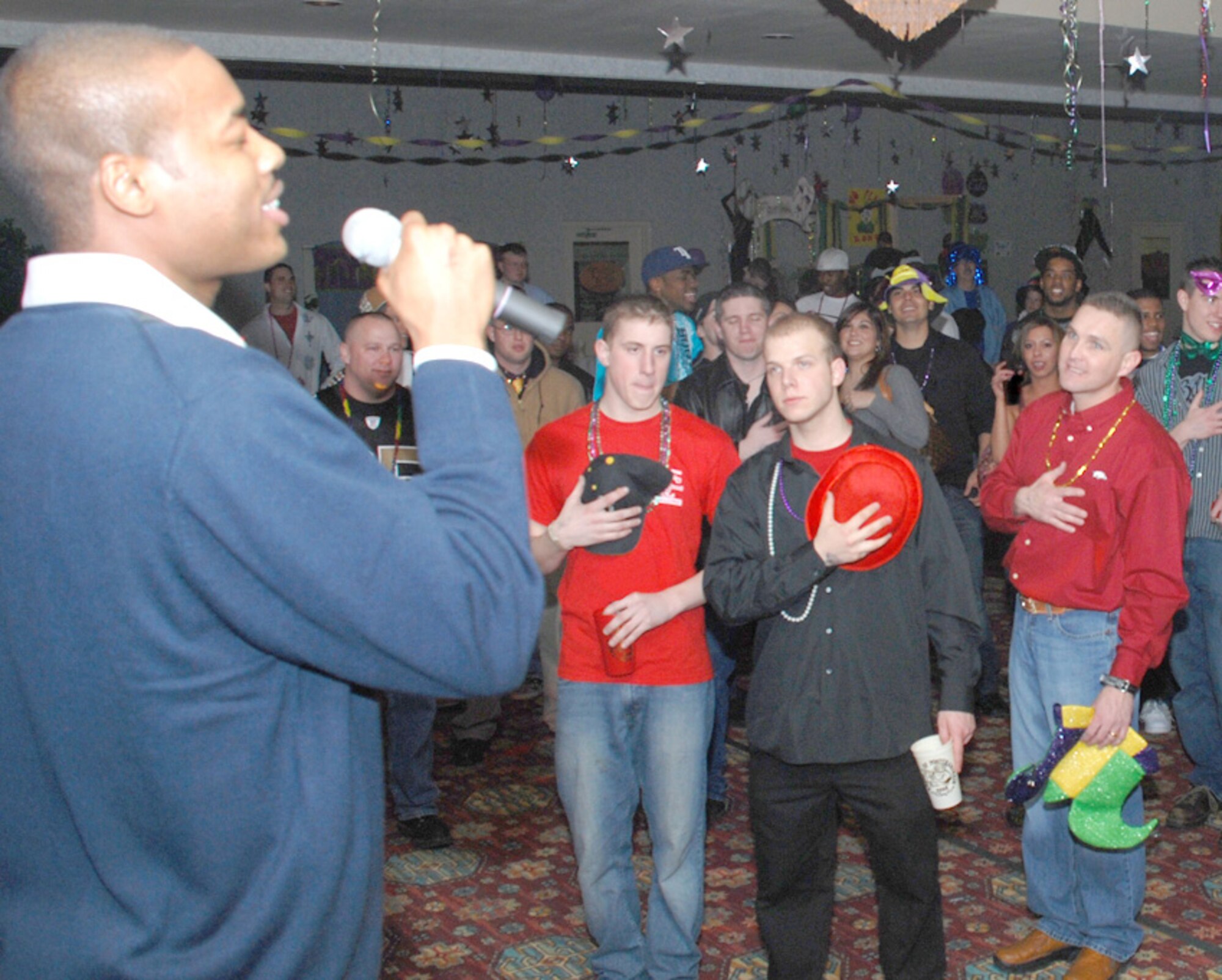 Airman 1st Class Oranzie Simmons, 90th Security Support Squadron, sings the National Anthem during the Mardi Gras celebration Feb. 1. Many of the party goers stopped what they were doing to sing along and render courtesy for the anthem.