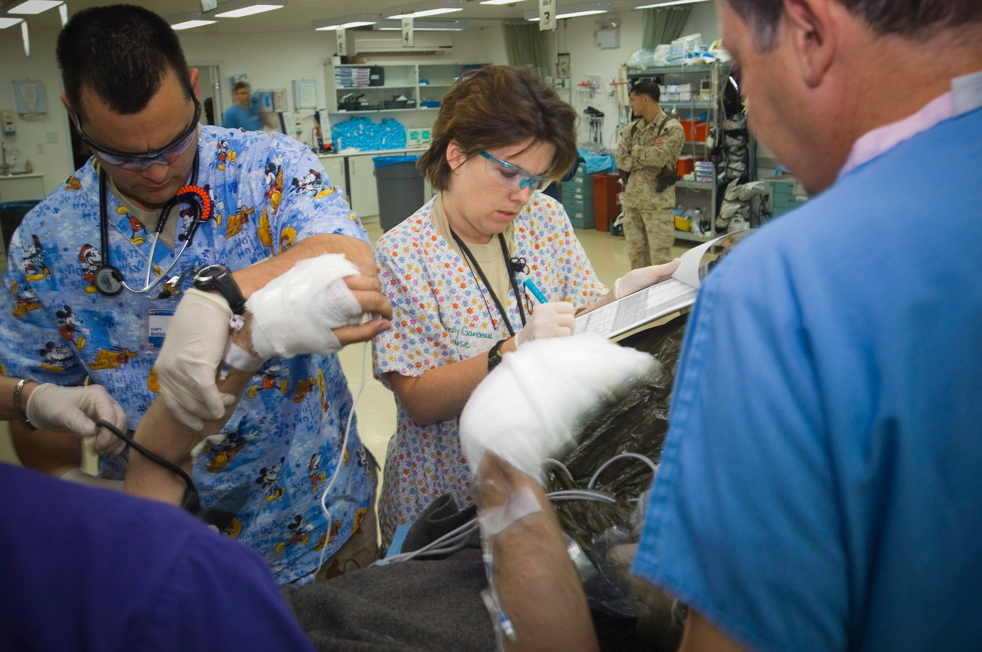 Capt. Shelly Garceau records vital signs in the Air Force Theater Hospital at Balad Air Base, Iraq, for a Marine who suffered burns on his face and arms. Captain Garceau is an emergency room nurse who is deployed from Wilford Hall Medical Center, San Antonio, Texas. (U.S. Air Force photo/Tech. Sgt. D. Clare) 