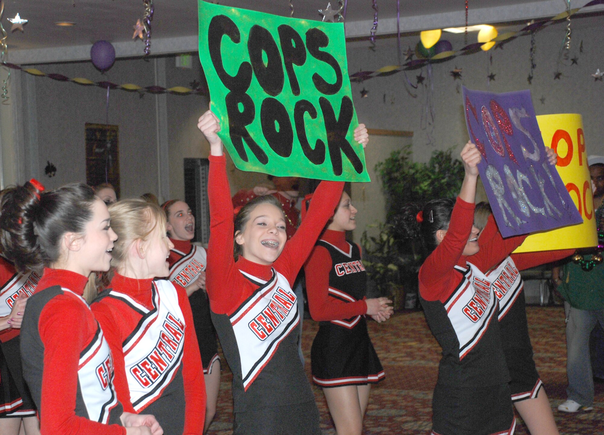 Cheerleaders from Central High School march around the main area shouting and presenting home-made posters for the hourly float displays during the Mardi Gras celebration Feb. 1 at the Trail’s End Club. The cheerleaders performed at the beginning of the party.
