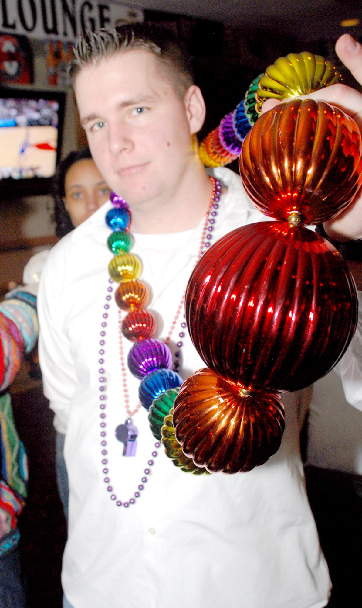 Senior Airman Michael Duncan, 90th Missile Security Forces Squadron, wields beads that he earned during the Mardi Gras party at the Trail’s End Club Feb. 1.