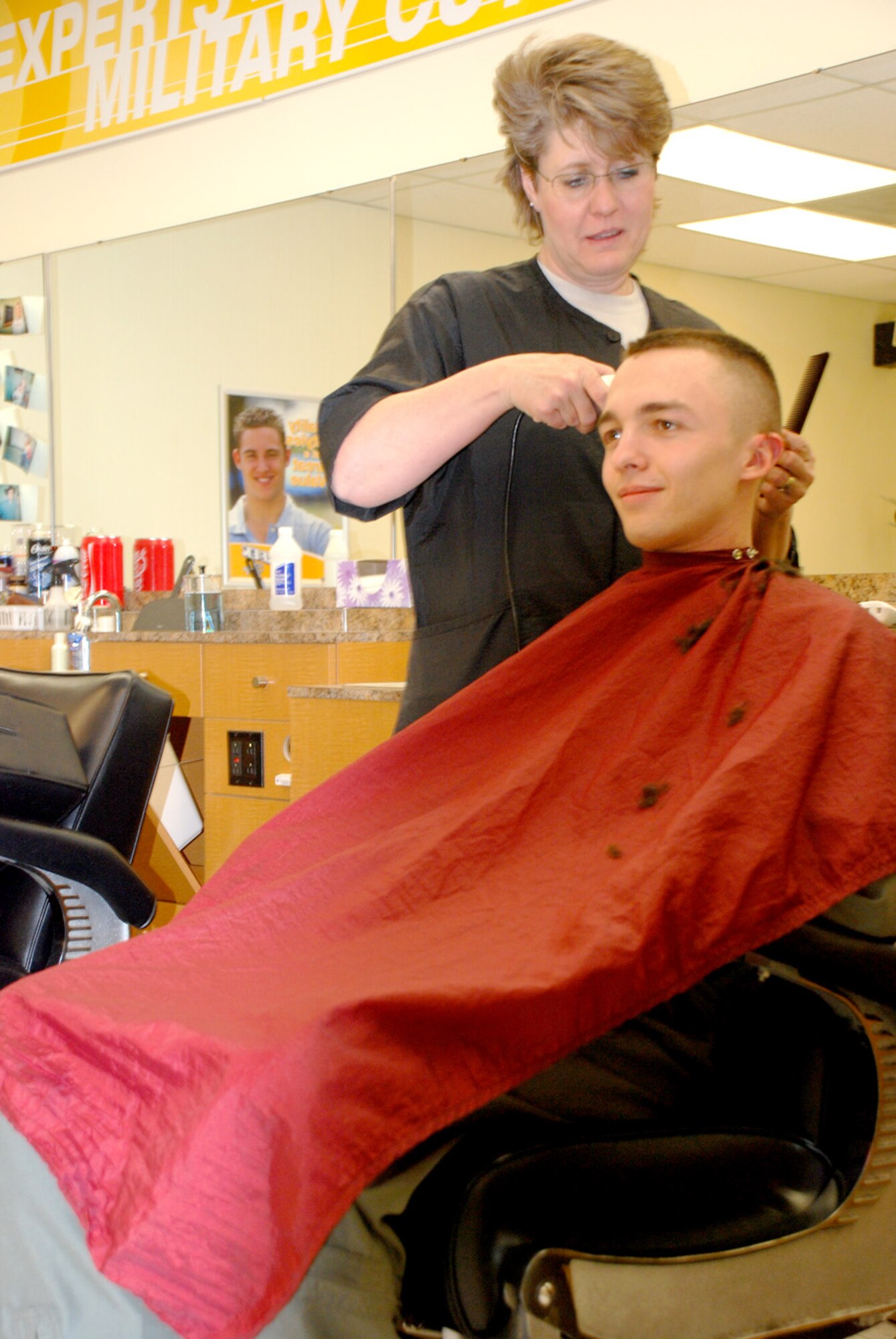 Karen Koch, civilian barber, performs a haircut for 1st Lt. Joe Liles, 90th Operations Group, at the BX barbershop Jan. 31. The barbershop is open Monday through Friday from 8 a.m. to 6 p.m. (U.S. Air Force photo/Airman 1st Class Daryl Knee).
