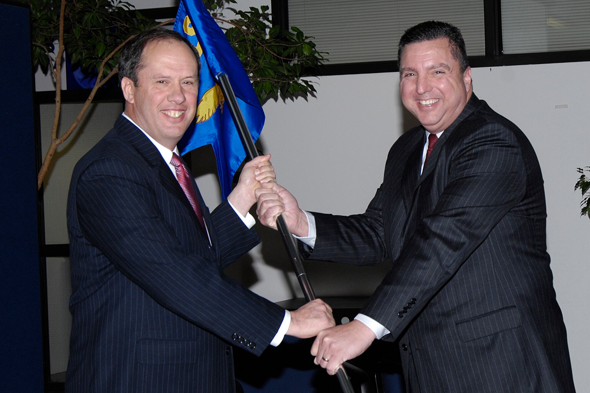 Director of the 653rd Electronic Systems Wing Bruce Hevey (left) passes the 853rd Electronic Systems Group flag to Ronnie Carter during an assumption of leadership ceremony for the group Feb. 7. Prior to that, Mr. Carter had served as deputy director of the Cryptologic Systems Group at Lackland AFB in San Antonio, Texas, since September 2000. (U.S. Air Force photo by Linda LaBonte Britt.)