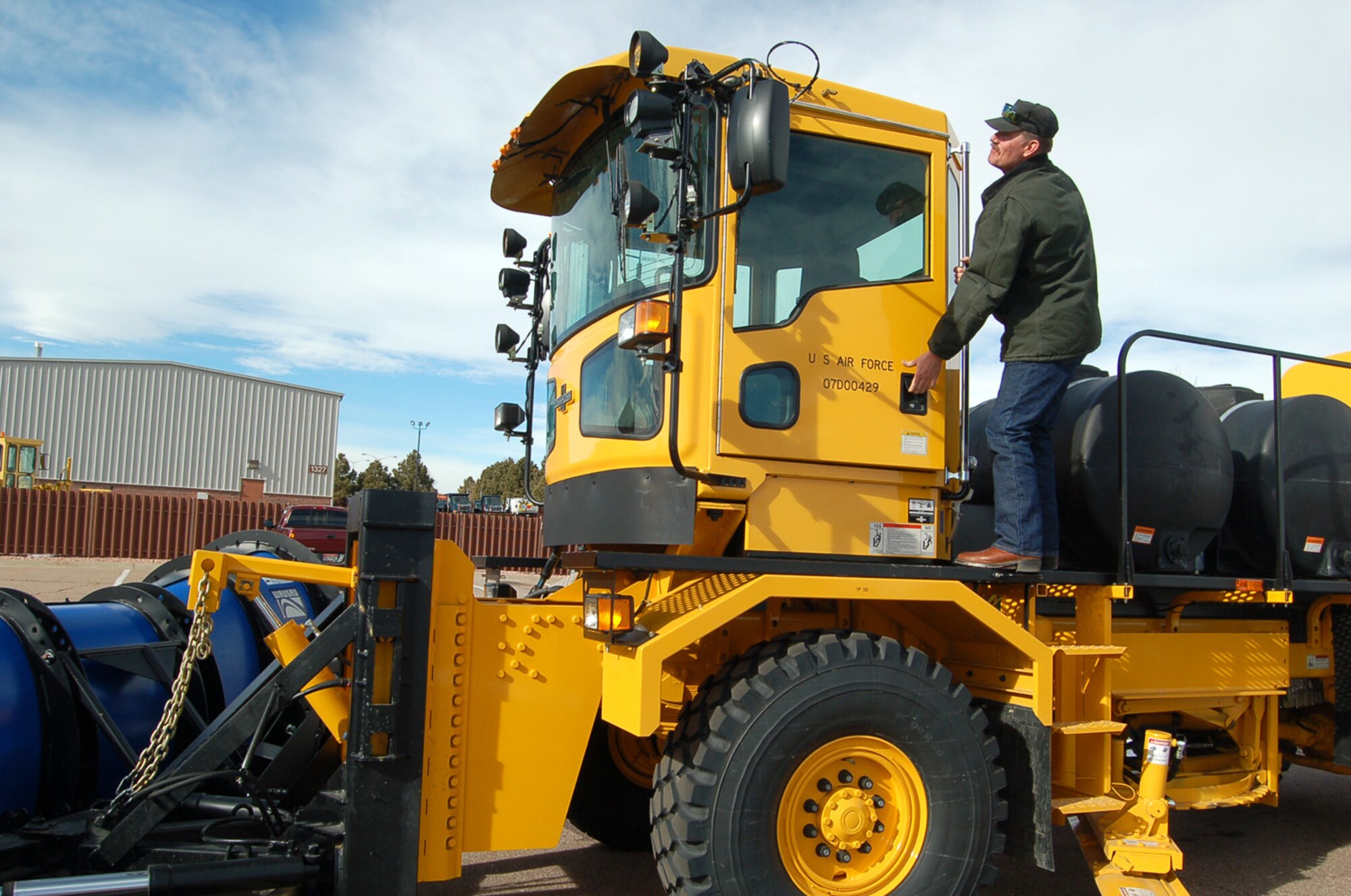 Kevin Schmit, work leader for the 21st Civil Engineer Squadron’s heavy hardware shop, shows off one of the newest pieces of equipment used to clear snow from the base’s flight line. Mr. Schmit and his team make sure Peterson’s roads, parking lots and runways remain clear during winter snow storms. (U.S. Air Force photo/Corey Dahl)