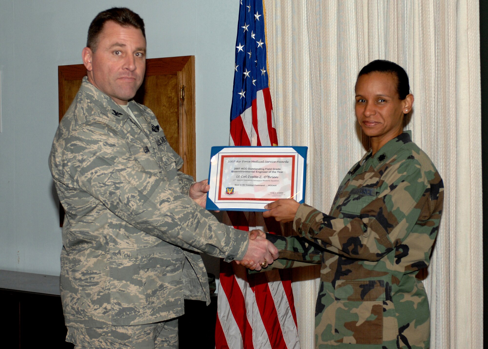CANNON Air Force Base,, NM -- Colonel Timothy Leahy, 27th Special Operations Wing commander, presents Lt. Col. Ivette O'Brien, 27th Special Operations Wing Inspector General, the 2007 Air Combat Command Outstanding Field Grade Base Environmental Engineer award on Feb. 5. Colonel O'Brien accepted the award on behalf of the 27th Special Operations Aeromedical Dental Squadron. (US Air Force photo by Airman 1st Class Evelyn Chavez)  