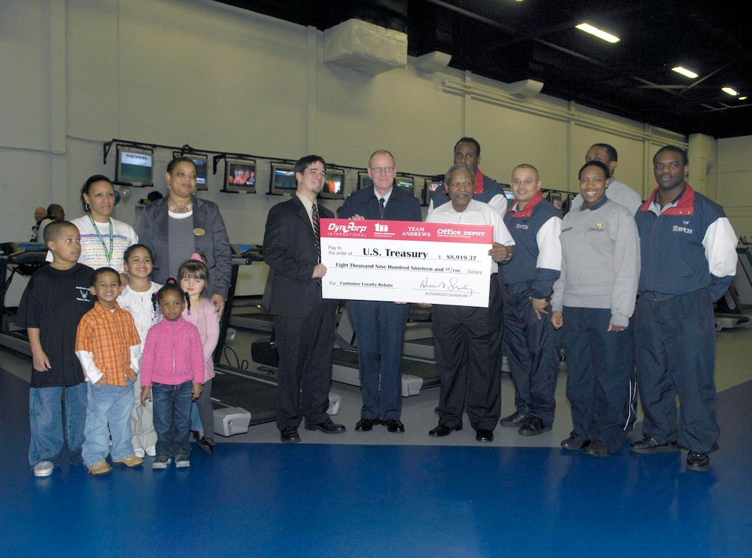 Col. Paul R. Ackerley, 316th Wing commander, accepts a check with members of the 316th Services Squadron as they receive a refund from Office Depot for $8,919.7, at the West Fitness Center here on Feb. 1. The check was given as a rebate for purchases made throughout the year. The refund will be used for quality of life programs like the fitness center and reading materials for the child development centers. (US Air Force/SrA Renae Kleckner)