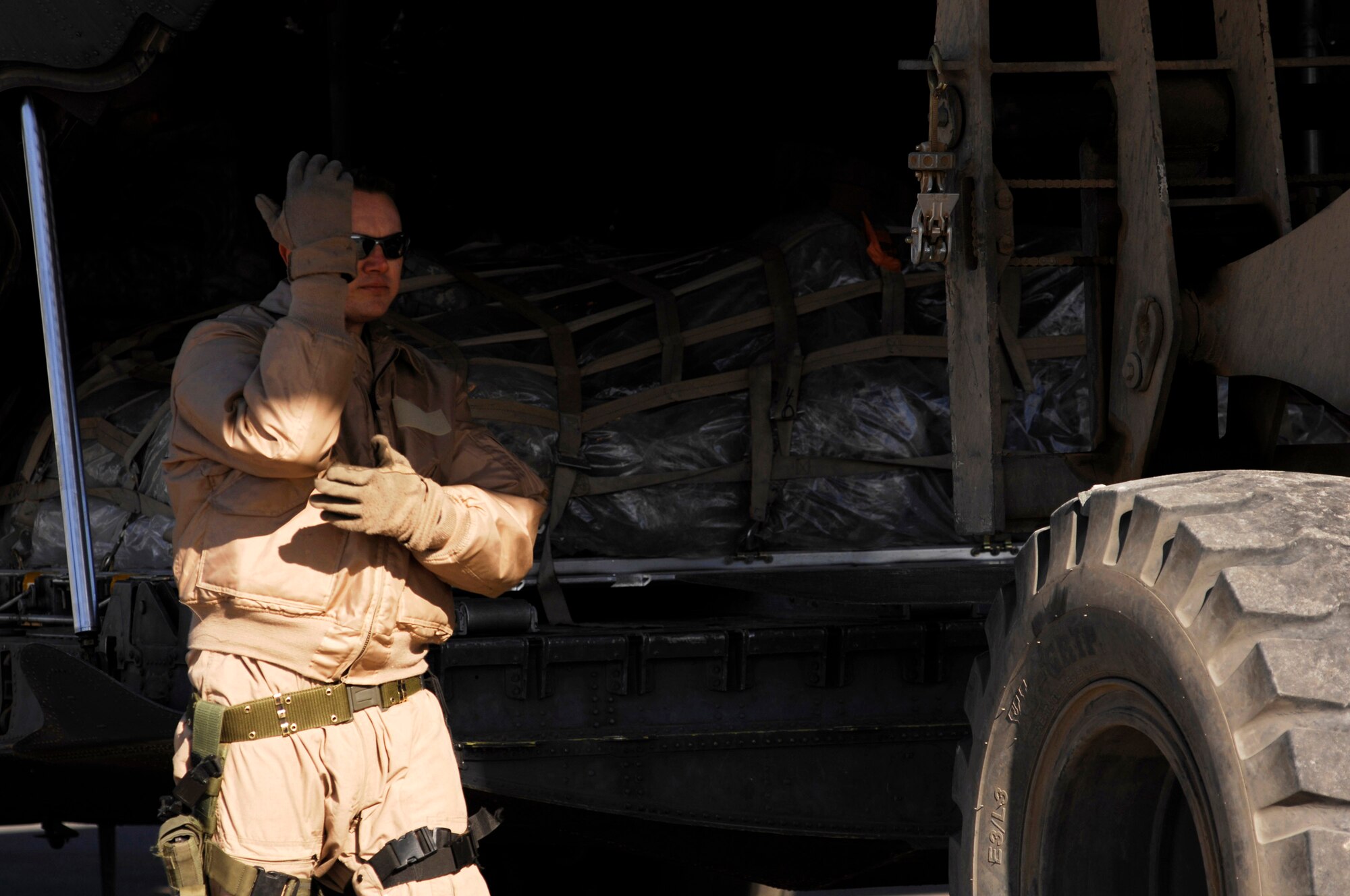 Senior Airman Kenny Harmon marshals a cargo pallet unto a C-130 Hercules Feb. 4 at a Southwest Asia air base. Airman Harmon, a 737th Expeditionary Airlift Squadron C-130 loadmaster, is deployed in support of operations Enduring Freedom and Iraqi Freedom and a part of his duties as loadmaster is to ensure the safety of members on board the aircraft while being transported throughout the area of responsibility. (U.S. Air Force photo/Staff Sgt. Patrick Dixon)
