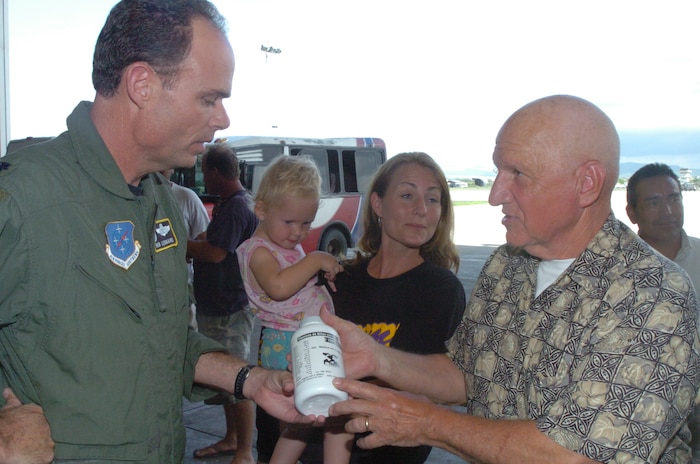 The 478th Expeditionary Operations Squadron commander, Lt.Col. Robert Leonard, accepts a bottle of children’s vitamins to donate to Shekinah Orphanage from Bob Eredics, Vitamins for the World director. The Coast Guard, Air Force, Vitamins for the World and Extreme Response International worked together to bring over one million vitamins to less fortunate children and adults in Ecuador. (U.S. Air Force photo by Capt. Ashley Norris)