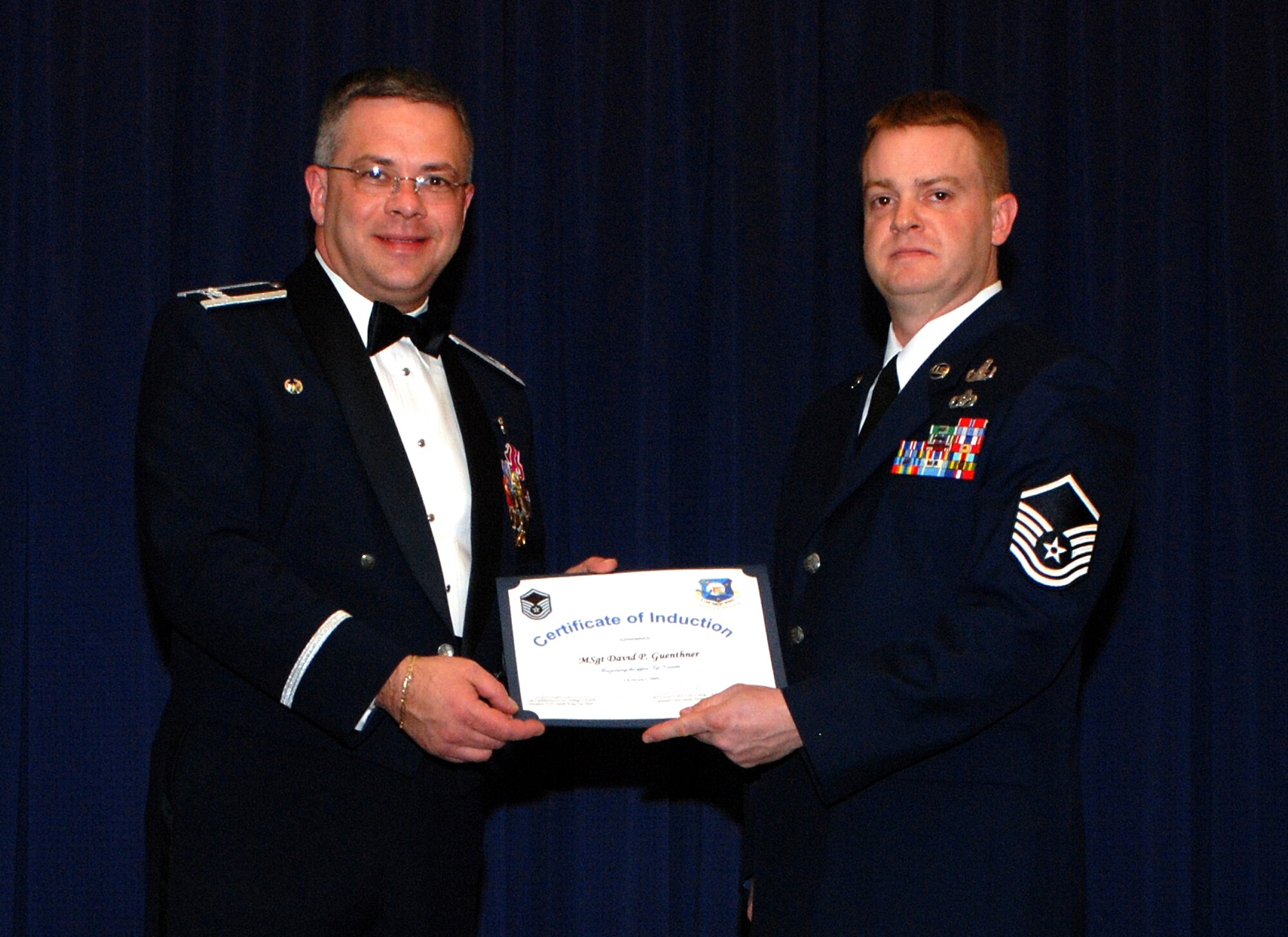 The Air Force Reserve's 512th Airlift Wing Commander Col. Randal L. Bright presents Master Sgt. David Guenthner, 512th Explosive Ordnance Flight, a certificate at the senior NCO induction ceremony Feb. 2 at The Landings, Dover Air Force Base, Del. The master sergeant was one of 20 Liberty Wing members  who were welcomed into the ranks of the senior NCO corps.  (U.S. Air Force photo\Staff Sgt. Steve Lewis)