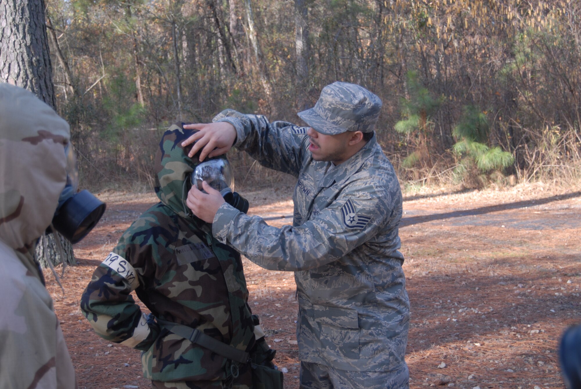 Staff Sgt. Richard Brown, 43rd Civil Engineer Squadron, instructs on how to properly wear a gas mask during Ability to Survive and Operate Training here Feb. 7. (U.S. Air Force Photo by 2nd Lt. Chris Hoyler)