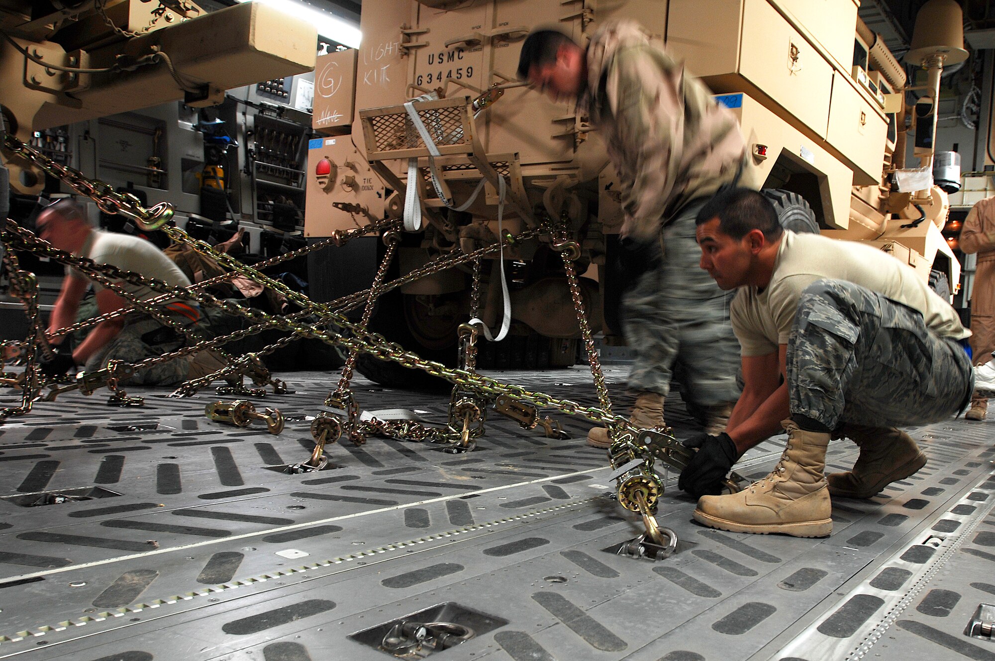 SOUTHWEST ASIA -- Airmen from the 386th Expeditionary Logistics Readiness Squadron's aerial port flight secure Mine Resistant Ambush Protected vehicles to the flooring of a Globemaster III cargo bay at a Southwest Asia air base Feb. 8, 2008. The MRAP vehicles are a family of armored fighting vehicles designed to survive various types of improvised explosive device attacks and ambushes. These vehicles are being delivered to the Marines throughout the area of responsibility supporting Operation Iraqi Freedom.  (U.S. Air Force photo/ Staff Sergeant Patrick Dixon) 