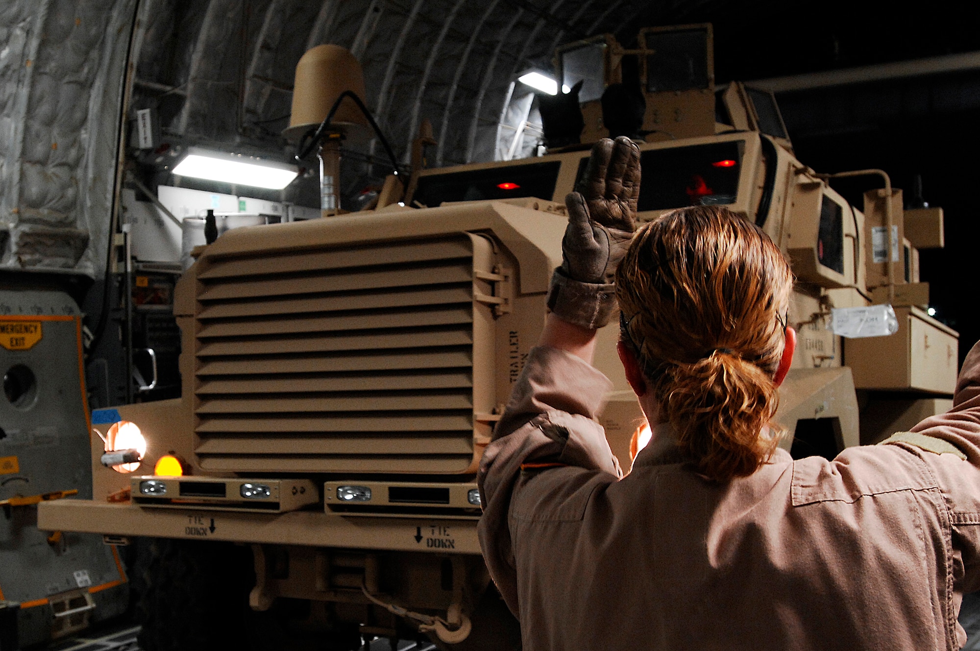 SOUTHWEST ASIA -- Senior Airman Leah Farias, a C-17 loadmaster with the 816th Expeditionary Airlift Squadron, marshals a Mine Resistant Ambush Protected vehicle into the cargo bay of a Globemaster III aircraft at a Southwest Asia air base Feb. 8, 2008. The MRAP vehicles are a family of armored fighting vehicles designed to survive various types of improvised explosive device attacks and ambushes. These MRAP vehicles are being delivered to the Marine Corps throughout the area of responsibility in support of Operation Iraqi Freedom. (U.S. Air Force photo/ Staff Sergeant Patrick Dixon)