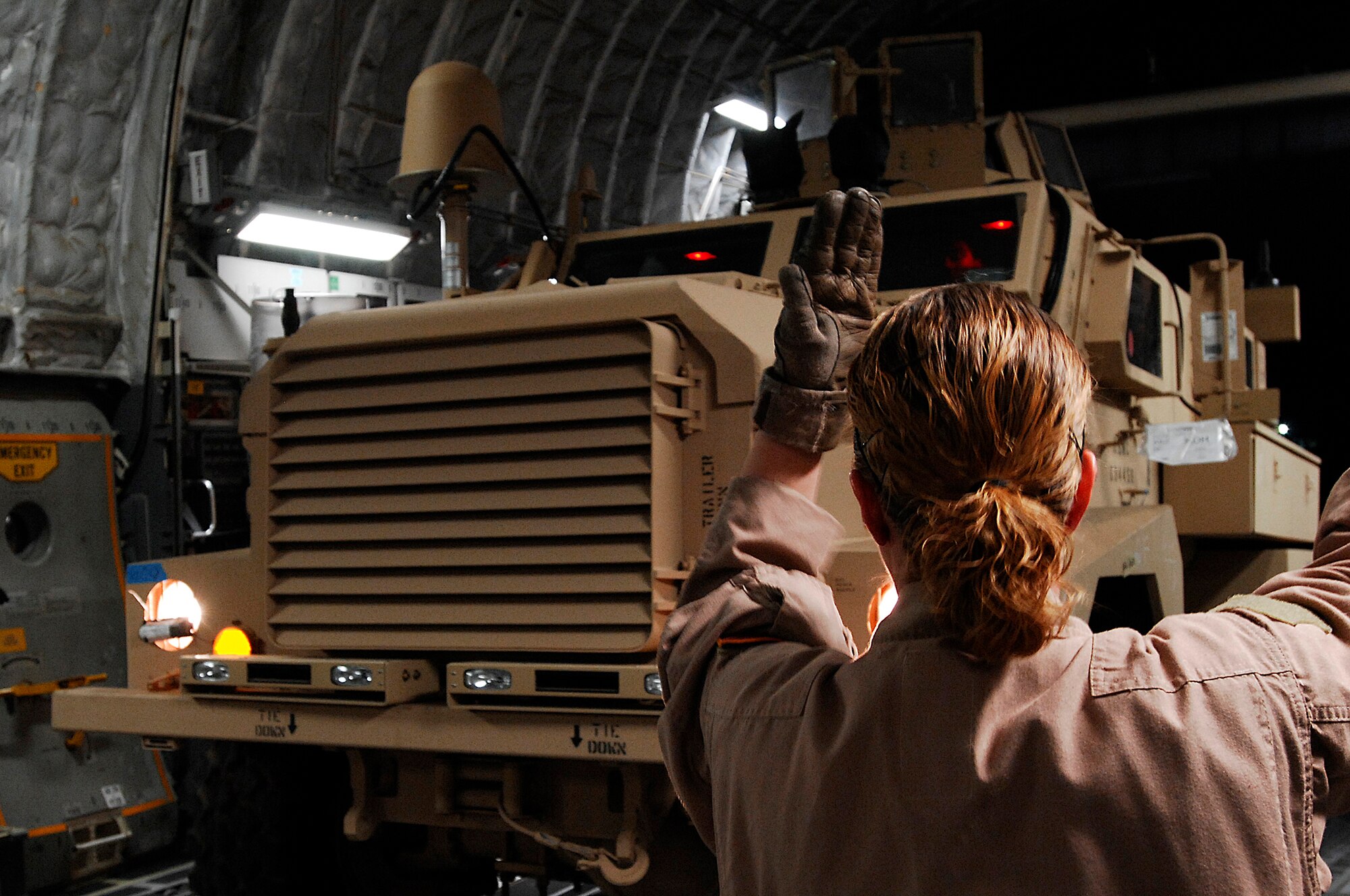 SOUTHWEST ASIA -- Senior Airman Leah Farias, a C-17 loadmaster with the 816th Expeditionary Airlift Squadron, marshals a Mine Resistant Ambush Protected vehicle into the cargo bay of a Globemaster III aircraft at a Southwest Asia air base Feb. 8, 2008. The MRAP vehicles are a family of armored fighting vehicles designed to survive various types of improvised explosive device attacks and ambushes. These MRAP vehicles are being delivered to the Marine Corps throughout the area of responsibility in support of Operation Iraqi Freedom. (U.S. Air Force photo/ Staff Sergeant Patrick Dixon)