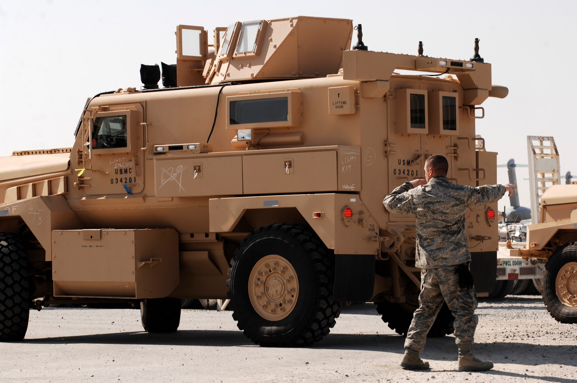 SOUTHWEST ASIA -- Staff Sgt. Michael Cambridge, 386th Expeditionary Logistics Readiness Squadron, non commissioned officer in charge of special handling, spots a Mine Resistant Ambush Protected vehicle into the cargo yard at a Southwest Asia air base Feb. 5, 2008. The MRAP vehicles are a family of armored fighting vehicles designed to survive various types of improvised explosive device attacks and ambushes. These MRAP vehicles are being delivered to the Marine Corps throughout the area of responsibility in support of Operation Iraqi Freedom.  (U.S. Air Force photo/ Staff Sergeant Patrick Dixon)