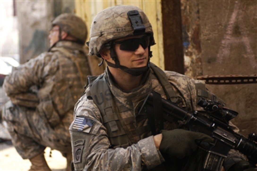 U.S. Army Sgt. Brandon Ryan (right) and Spc. Eric Glowacki sit back-to-back as they provide rear security during a patrol in Baghdad, Iraq, on Jan. 25, 2008.  Ryan and Glowacki are attached to the Armyís 3rd Platoon, Charlie Company, 1st Battalion, 504th Parachute Infantry Regiment.  