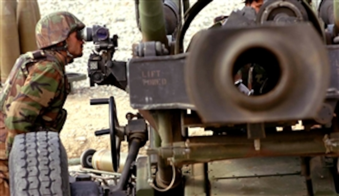 An Afghanistan National Army artilleryman looks through the sight lenses of a Howitzer while receiving training from U.S. Army artillerymen assigned to the 319th Airborne Field Artillery Regiment, Jan. 28, 2008, at Forward Operating Base Kalagush, Nuristan province, Afghanistan.