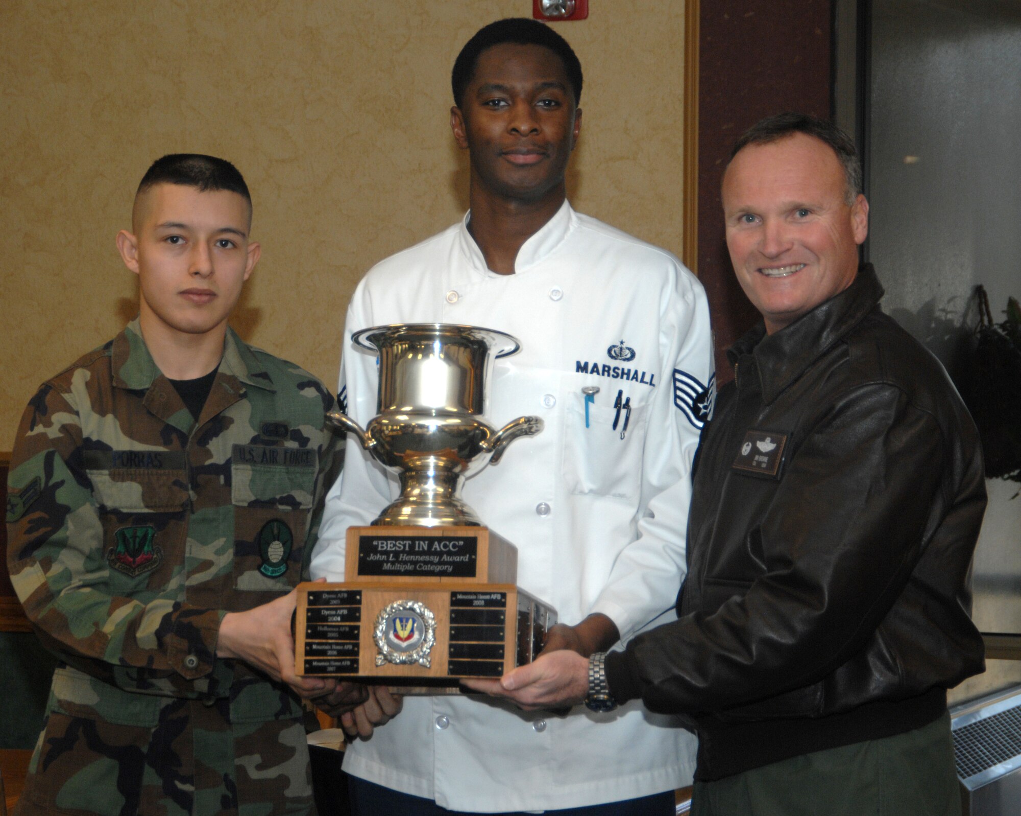 MOUNTAIN HOME AIR FORCE BASE, Idaho -- Left, Airman 1st Class Luis Porrasvargas and Staff Sgt. LaMonte Marshall, both from the 366th Services Squadron food services team, pose with Col. James Browne, 366th Fighter Wing commander, with the Air Combat Command level John L. Hennessy Trophy at the Wagon Wheel Dining Facility here Jan. 23. This marks the third straight year the team won at ACC level. An Air Force level evaluation team will visit the base Feb. 13 through 17 to rate the food services team against others from each major command including active, Guard and Reserve installations. Established in 1956, the award is presented to the base with the most impressive food service in the Air Force. (U.S. Air Force photo/Airman 1st Class Stephany Miller)