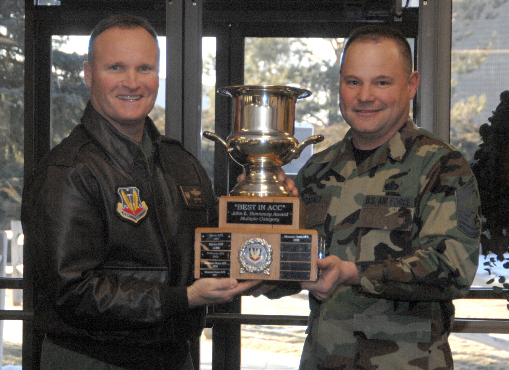 MOUNTAIN HOME AIR FORCE BASE, Idaho -- Left, Col. James Browne, 366th Fighter Wing commander, accepts the Air Combat Command level John L. Hennessy Award from Chief Master Sgt. Don Carney, ACC representative, at the Wagon Wheel Dining Facility here Jan. 23 before presenting it to the 366th Services Squadron food services team. This marks the third straight year the team won at ACC level. An Air Force level evaluation team will visit the base Feb. 13 through 17 to rate the food services team against others from each major command including active, Guard and Reserve installations. Established in 1956, the award is presented to the base with the most impressive food service in the Air Force. (U.S. Air Force photo/Airman 1st Class Stephany Miller)