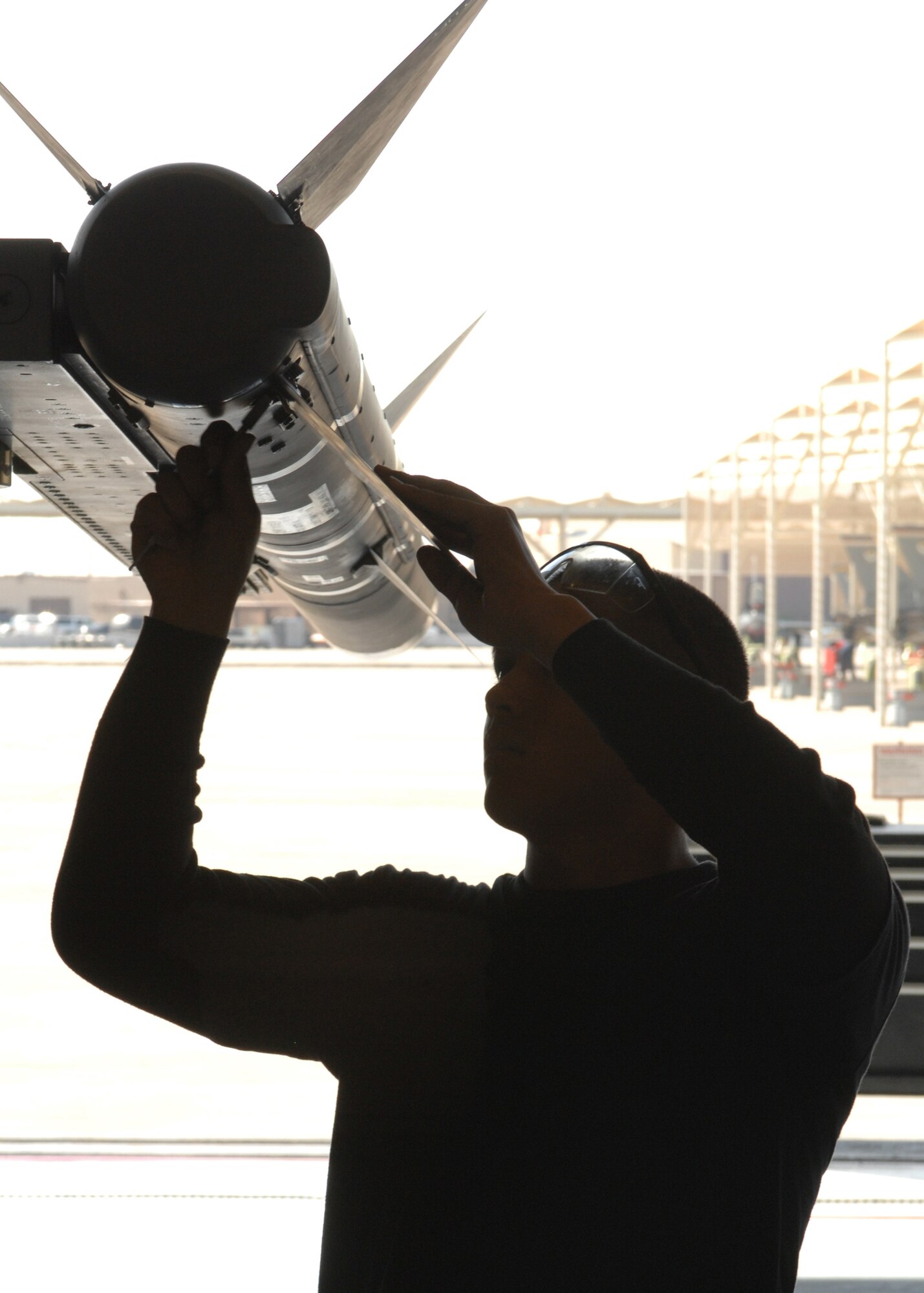 Senior Airman Treston Kaneao from the 61st Aircraft Maintenance Unit attaches the fins to a AIM-120 missile during the Weapons Load Crew Competition here at Luke on Feb 8. The 310th AMU crew 16 beat out the 61st AMU crew M80 during the competition. (photo by Tech. Sgt. Raheem Moore)