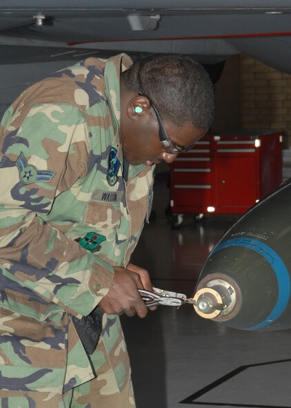 A1C Timothy Watson from the 310th Aircraft Maintenance Unit secures a MK-84LD bomb onto an F-16 during the Weapons Load Crew Competition here at Luke on Feb 8. The 310th AMU crew 16 beat out the 61st AMU crew M80 during the competition. (photo by Tech. Sgt. Raheem Moore)