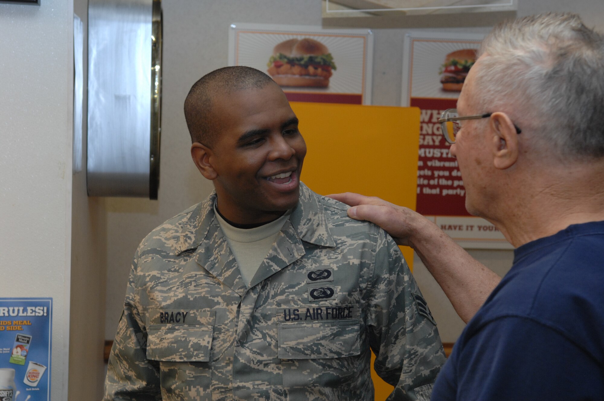 Retired Air Force Master Sgt. John Polonic, has a conversation with Senior Airman Herbert Bracy, Feb. 8, in the Ellsworth base exchange. Sergeant Polonic bought lunch for 105 service members in appreciation for their hard work and dedication to our country. (U.S. Air Force photo/ Airman 1st Class Adam Grant)