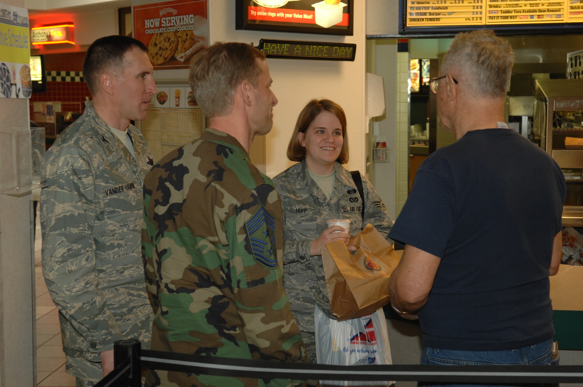 Retired Air Force Master Sgt. John Polonic converses with Col. Scott Vander
Hamm, 28th Bomb Wing commander, Chief Master Sgt. John Gillette, 28th BW
command chief and Senior Airman Shawna Hopp, from the 28th Civil Engineer Squadron,  Feb. 8, 2008, in the  base exchange at Ellsworth Air Force Base, S.D., after buying lunches for all members in uniform. For showing his appreciation to service members, Colonel Vander Hamm and Chief Gillette presented the retired sergeant with three different coins. (U.S. Air Force photo/ Airman 1st Class Adam Grant)
  