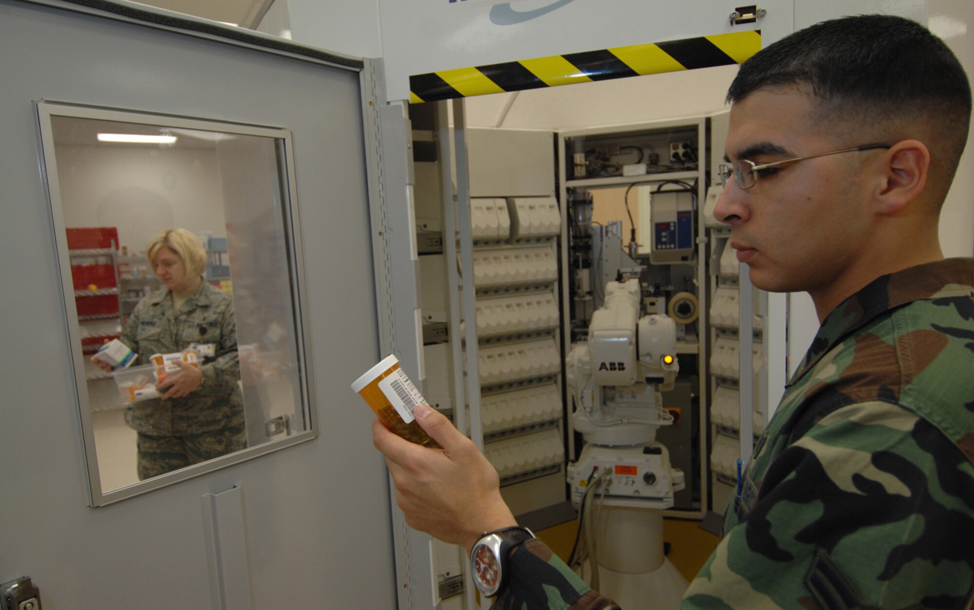 NELLIS AIR FORCE BASE, Nev.—Airman 1st Class Luis Alvarado, 99th Medical Support Squadron pharmacy technician, reviews a customer's prescription outside the Robotics Dispensing System at the satellite pharmacy here. (U.S. Air Force photo by Master Sgt. Kevin Gruenwald)