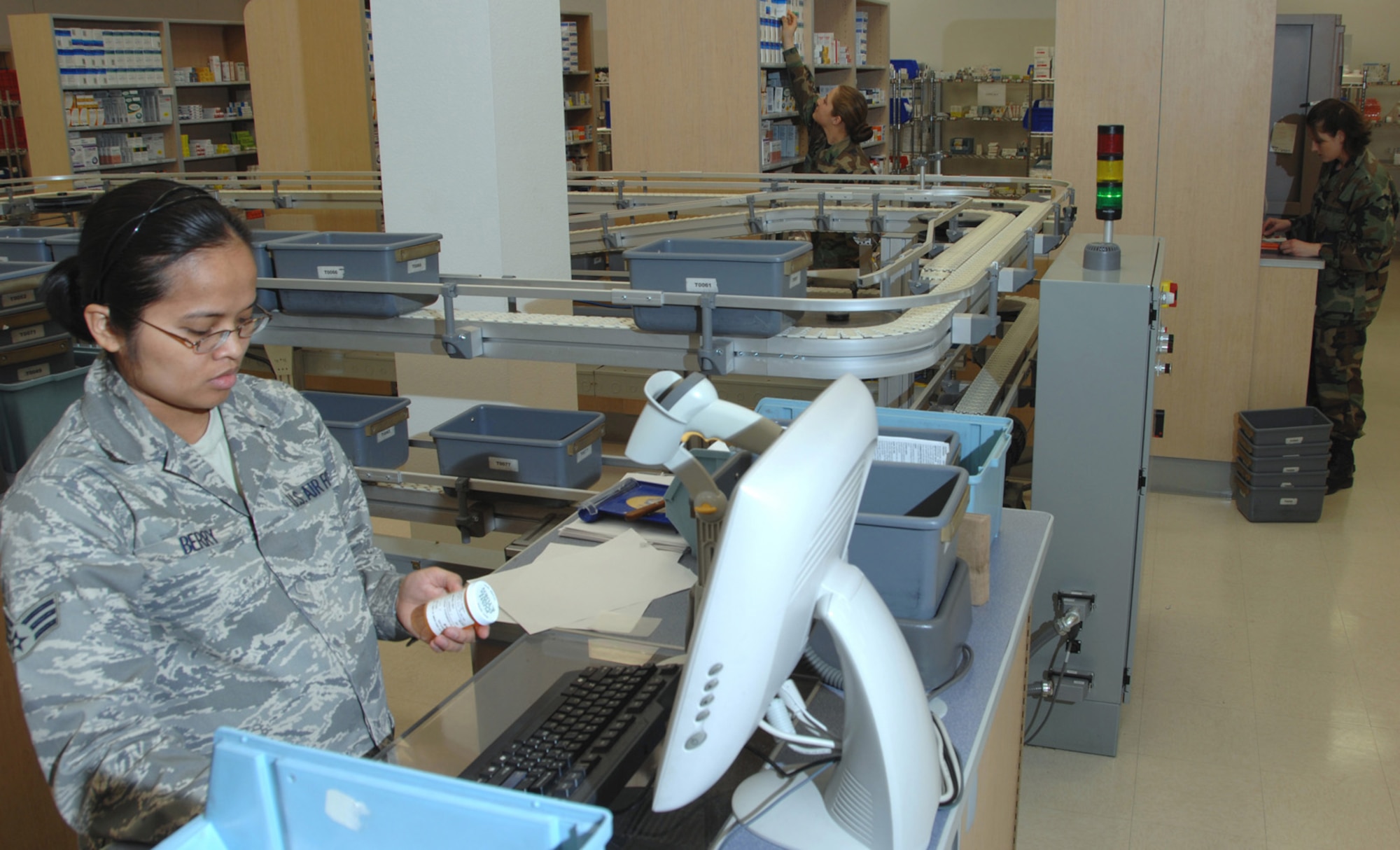 NELLIS AIR FORCE BASE, Nev.—Senior Airman Judith Berry, 99th Medical Support Squadron pharmacy technician, checks a prescription from the conveyor belt at the satellite pharmacy here before dispensing it to the customer. (U.S. Air Force photo by Staff Sgt. Scottie McCord)