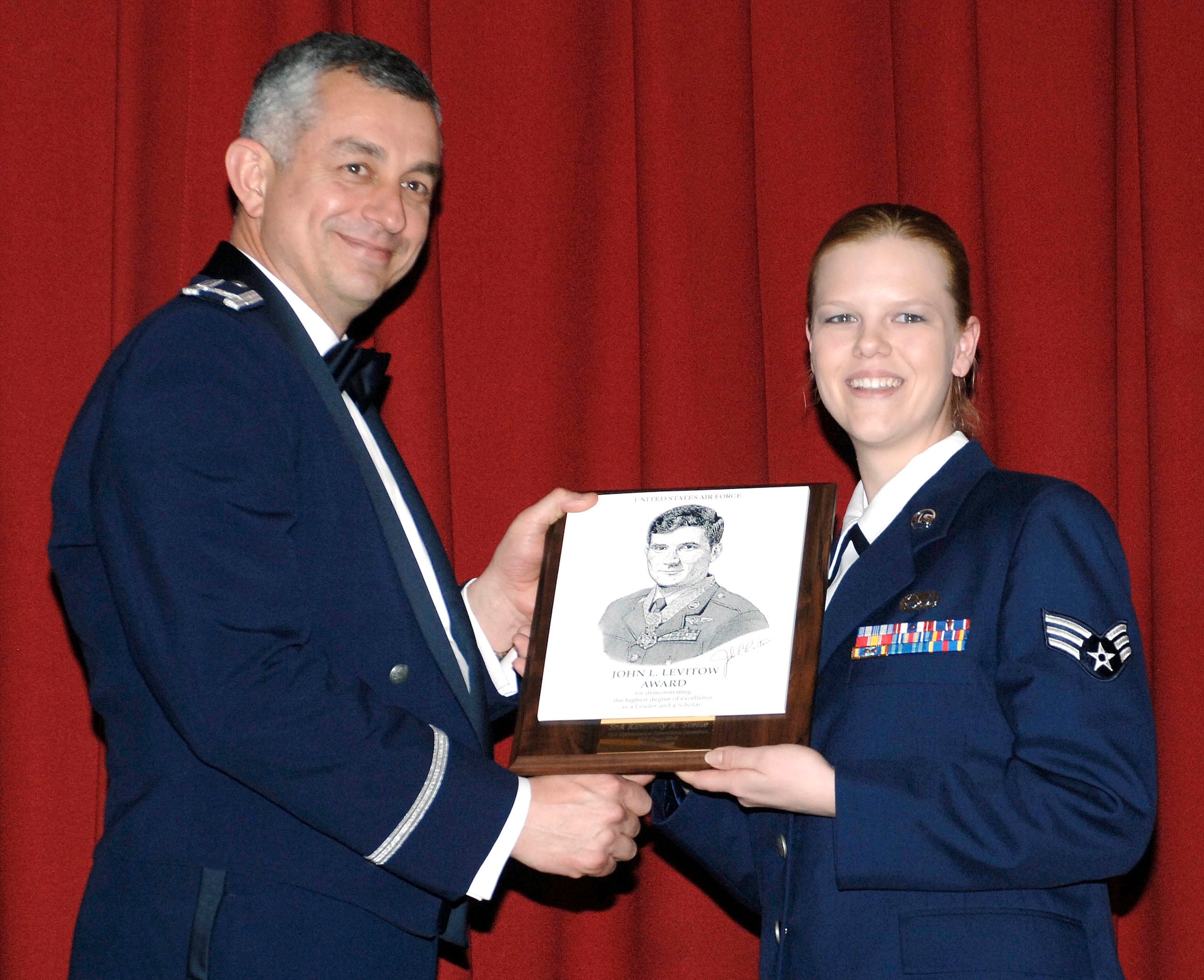 FAIRCHILD AIR FORCE BASE, Wash. –  Col. Roger Watkins, 92nd Air Refueling Wing vice commander, presents Senior Airman Kimberly Steele, 92nd Maintenance Operations Squadron data base manager, with the John L. Levitow award for demonstrating the highest degree of excellence as a leader and scholar. The award was given during the Airman Leadership School graduation at Club Fairchild Feb.7.  (U.S. Air Force photo/Staff Sgt. JT May III)