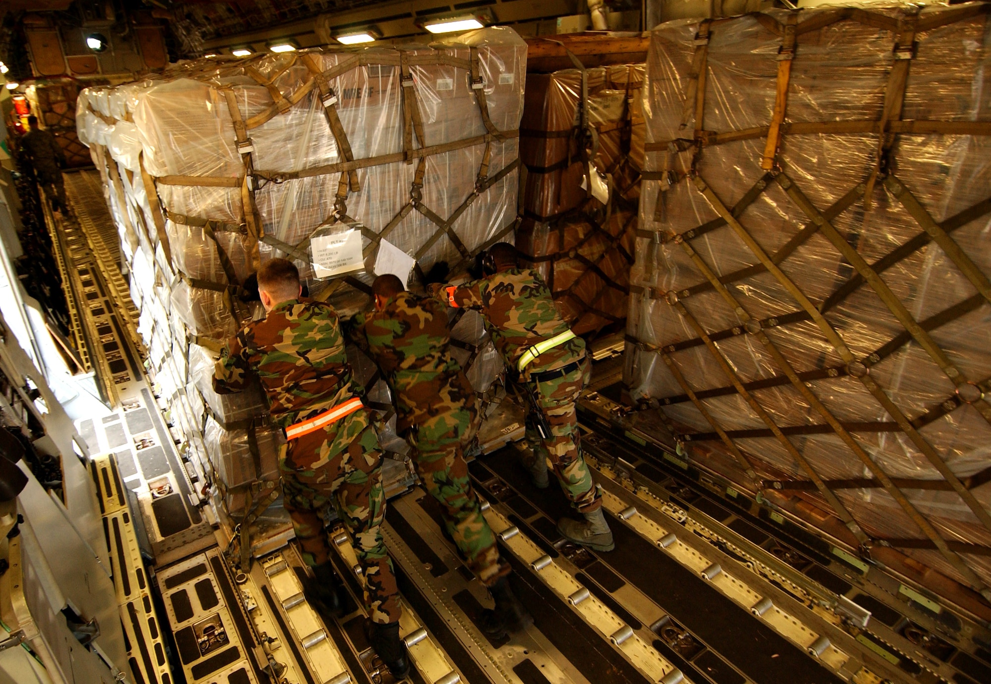 Airmen from the 733rd Air Mobility Squadron load cargo onto a C-17 Globemaster III from Elmendorf Air Force Base, Alaska, Feb. 8 at Kadena Air Base, Japan. The 733rd AMS loaded medical supplies, food rations and cold weather gear onto this C-17 and another from Hickam Air Force Base, Hawaii, bound for China. Recently, 19 Chinese provinces experienced the most severe winter storms in 50 years, imposing severe hardships on millions of Chinese citizens. U.S. Pacific Command coordinated the delivery of the humanitarian supplies to People's Liberation Army at Shanghai International Airport, China. (U.S. Air Force photo/Tech. Sgt. Rey Ramon)