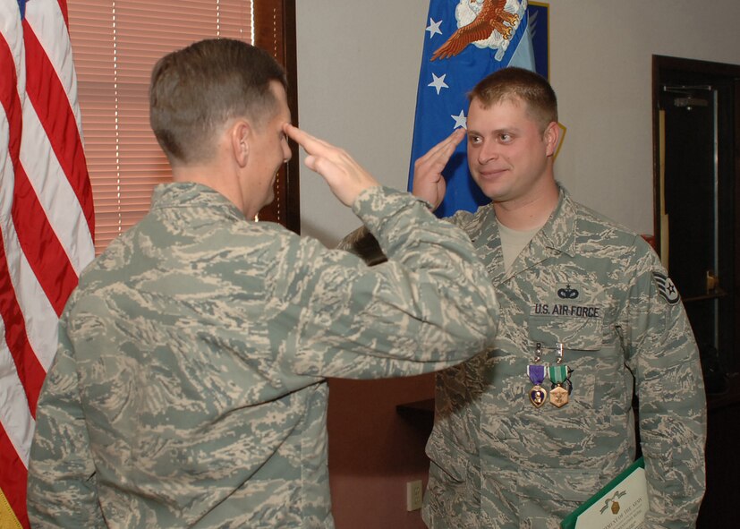 DYESS AIR FORCE BASE, Texas-- Col. Timothy Ray, 7th Bomb Wing Commander, presents Staff Sgt. Zebulen Miller, a military working dog handler from the 7th Security Forces Squadron, with the Purple Heart Medal for wounds received in combat at a Medal presentation held on Feb. 8. SSgt Miller was wounded by shrapnel from a mortar round.(U.S Air Force photo by Airman 1st Class Felicia Juenke)