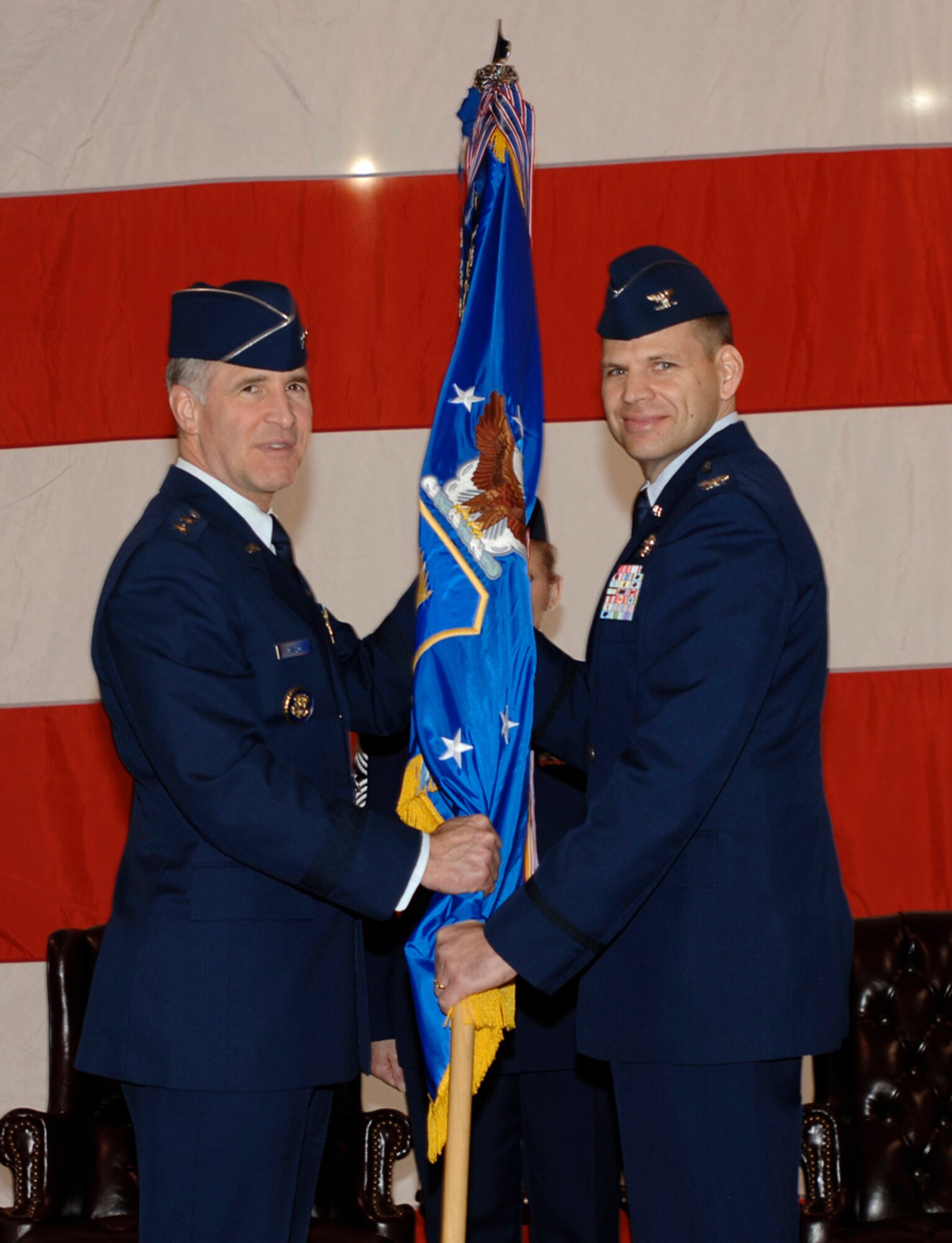 MCCONNELL AIR FORCE BASE, Kan. -- Maj. Gen. James Hawkins, left, 18th Air Force commander, Scott Air Force Base, Ill., , left, passes the 22nd Air Refueling Wing guidon flag to Col. James Vechery, right, giving him command of the wing at the wing change of command ceremony here, Feb. 8. Colonel Vechery succeeds Col. Donald Halpin who makes his transition from McConnell to work with the Air Mobility command staff. (Photo by Senior Airman Jamie Train)