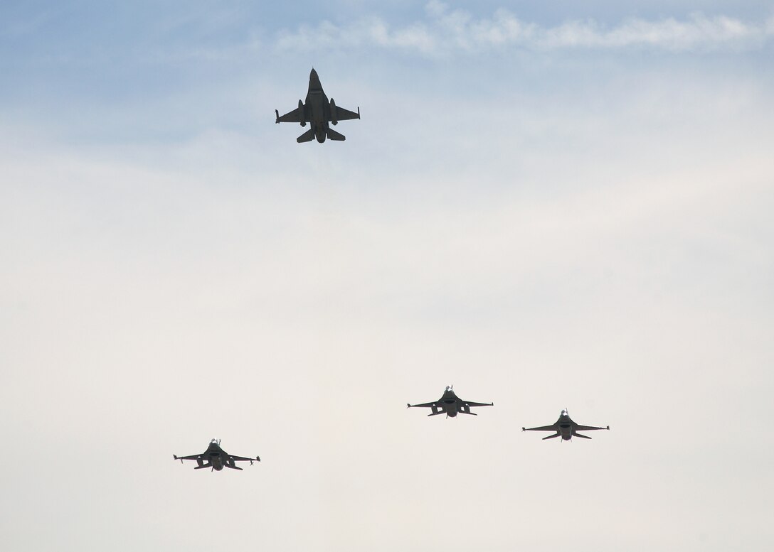 Four F-16 Fighting Falcons perform a missing-man formation as a tribute to Col. Bryan J. Gallagher, 95th Air Base Wing commander, during his memorial service at hangar 1820 here Feb. 11. Colonel Gallagher died Feb. 5. (Air Force Photo by Jet Fabara)