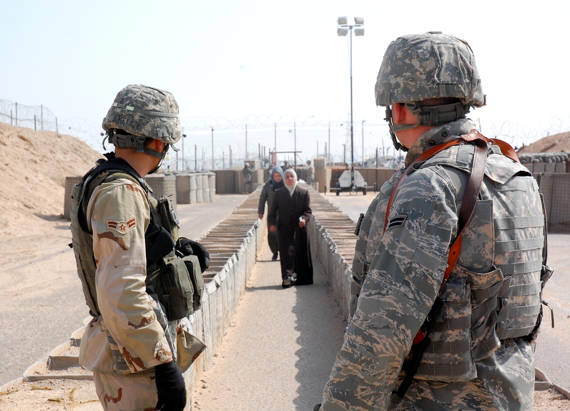 Airman 1st Class Shane Kelly (left) and Airman 1st Class Russ Stiegemeier prepare to process Iraqis Feb 10 who are visiting family members detained in the Theater Internment Facility at Camp Bucca, Iraq. Airmen deployed to the 886th Expeditionary Security Forces Squadron operate the TIF's vigorous visitation program which houses detainees who have been determined to be a security threat against Iraqi citizens or coalition forces. More than 1,700 friends and family members visit the detainees each week. Airman Kelly is deployed from Hickam Air Force Base, Hawaii and Airman Stiegemeier is deployed from Malmstrom AFB, Mont. Both are assigned to the 886th ESFS. (U.S. Air Force pPhoto/Capt. Jason McCree) 