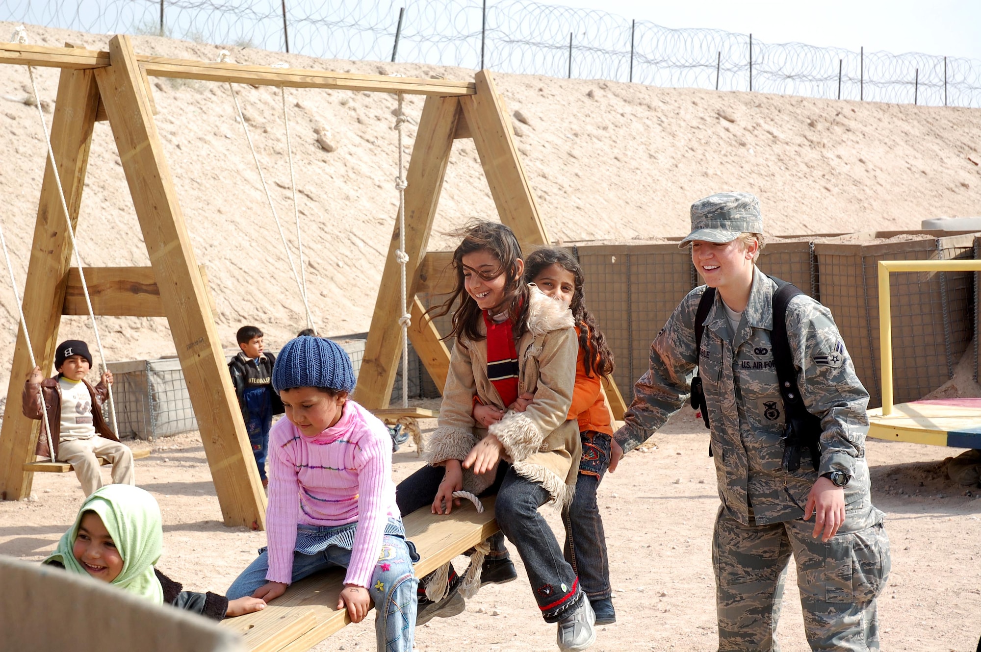 Airman 1st Class Sarah Coble plays with children Feb 10 who are visiting family and friends detained in the Theater Internment Facility at Camp Bucca, Iraq. Airmen deployed to the 886th ESFS operate the TIF's vigorous visitation program which houses detainees determined to be a security threat against Iraqi citizens or coalition forces. More than 1,700 friends and family members visit the detainees each week. Airman Coble is a 886th Expeditionary Security Forces Squadron member deployed from Keesler Air Force Base, Miss. (U.S. Air Force photo/Capt. Jason McCree) 