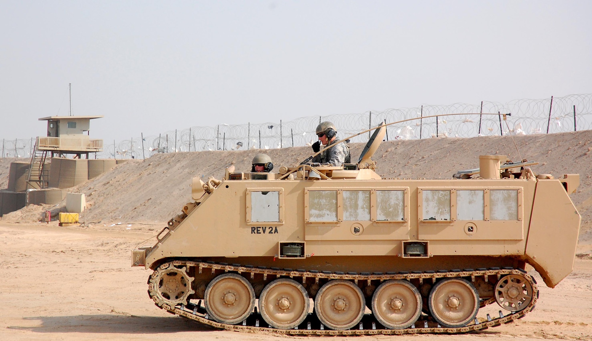 Senior Airman Travis Hummel (standing) and Airman 1st Class Adam Giebitz patrol Feb. 10 in an M-113 Armored Personnel Carrier at the Theater Internment Facility at Camp Bucca, Iraq. Airmen Hummel and Giebitz are deployed from Robins Air Force Base, Ga., and are assigned to the 886th Expeditionary Security Forces Squadron's quick response force. The QRF responds to issues within the TIF in which a show of force or escalation of force is required beyond the capabilities for the TIF's guard force. (U.S. Air Force photo/Capt. Jason McCree) 