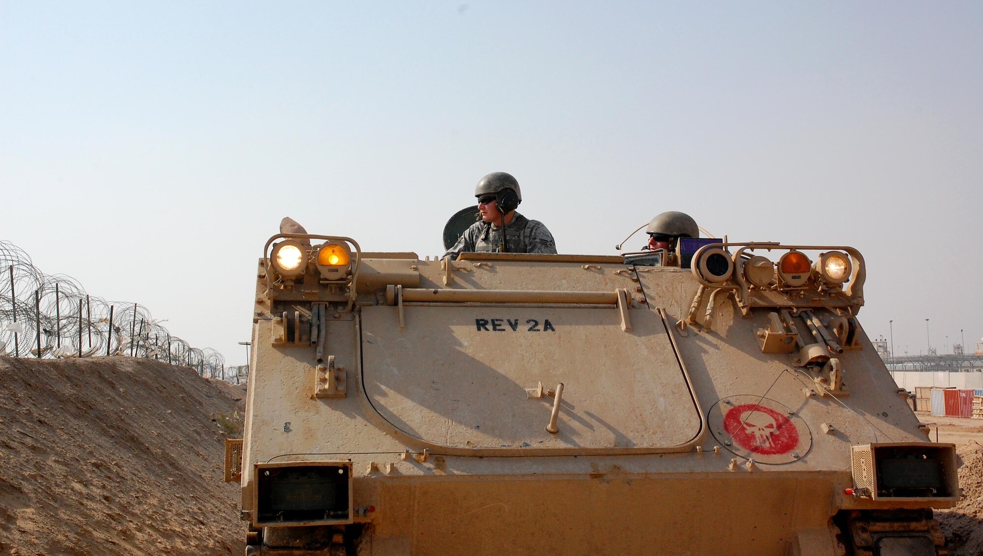 Senior Airman Travis Hummel (left) and Airman 1st Class Adam Giebitz patrol Feb. 10 in an M-113 Armored Personnel Carrier at the Theater Internment Facility at Camp Bucca, Iraq. Airmen Hummel and Giebitz are deployed from Robins Air Force Base, Ga., and are assigned to the 886th Expeditionary Security Forces Squadron's quick response force. The QRF responds to issues within the TIF in which a show of force or escalation of force is required beyond the capabilities for the TIF's guard force. (U.S. Air Force photo/Capt. Jason McCree) 