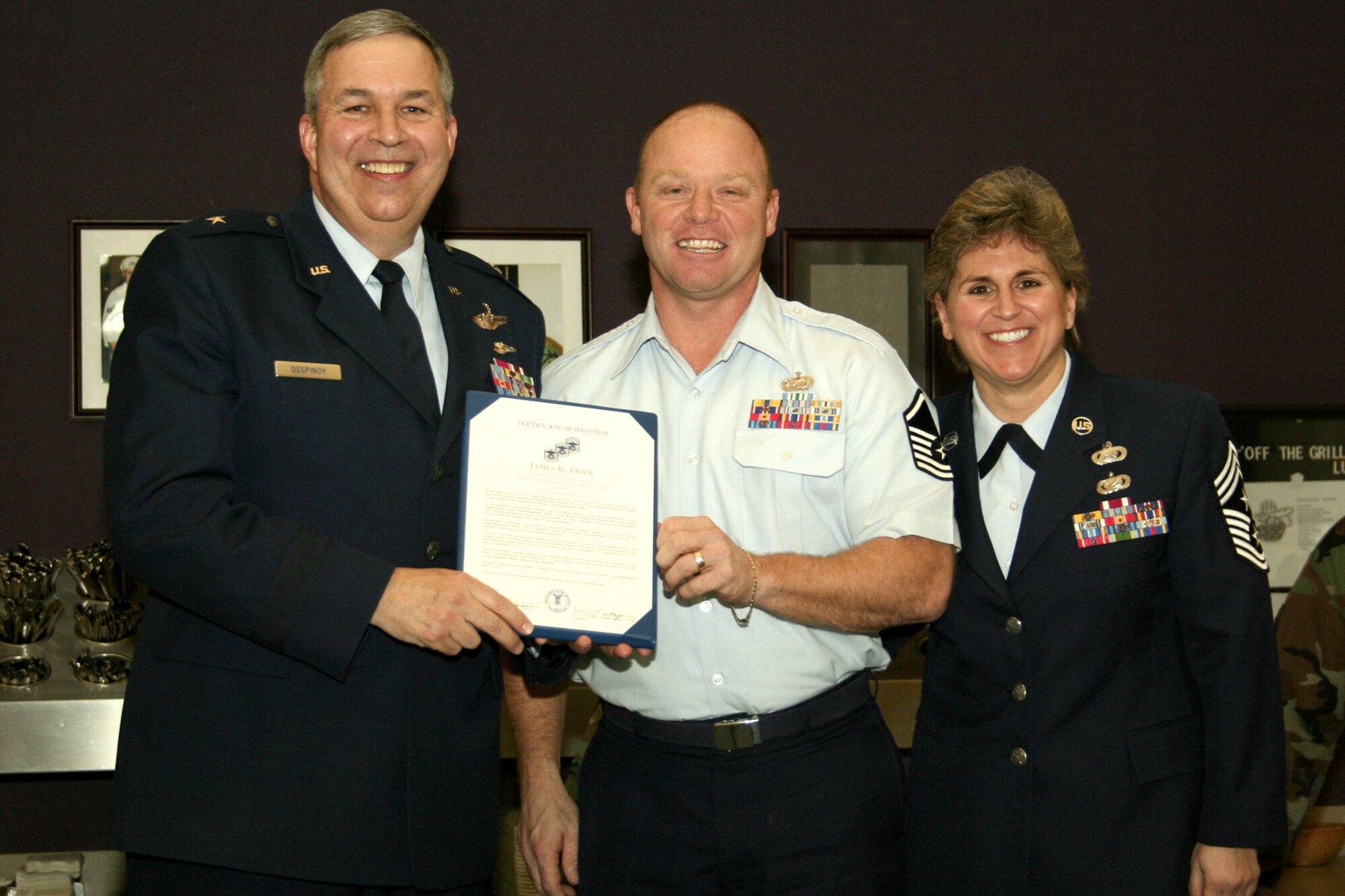 GRISSOM AIR RESERVE BASE, Ind., -- Brig. Gen. Dean Despinoy, 434th Air Refueling Wing commander, left, presents Master Sgt. Jim Frier, an administrative craftsman with the 434th ARW, a certificate recognizing his promotion to master sergeant. Chief Master Sgt. Peri Rogowski, 434th ARW command chief stands near. (U.S. Air Force photo Tech. Sgt. Patrick Kuminecz)