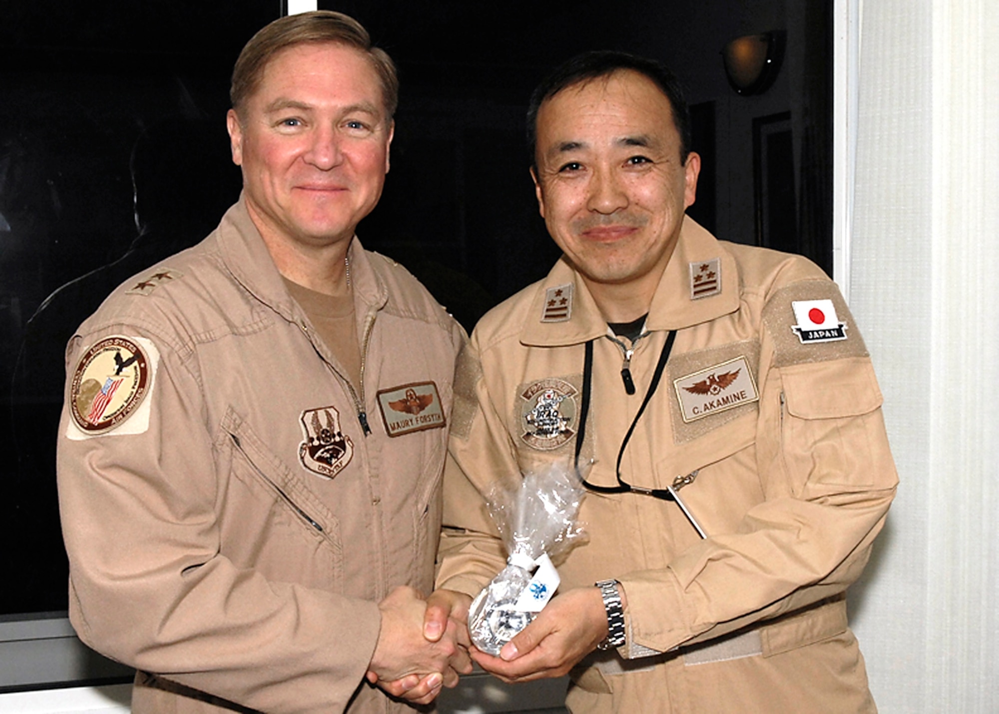 Maj. Gen. Maury Forsyth, Combined Air and Space Operations Center (CAOC), Deputy Commander, presents a gift on behalf of Lt. Gen. Gary North, CAOC, Commander, to Col. Chiyohiro Akamine, Commander, Iraq Reconstruction Support Airlift Wing, Japanese Self Air Defense, during his visit to the CAOC on February 9, 2008. (RELEASED) (U.S. Air Force Photo By: Staff Sgt. Christina M. Styer)