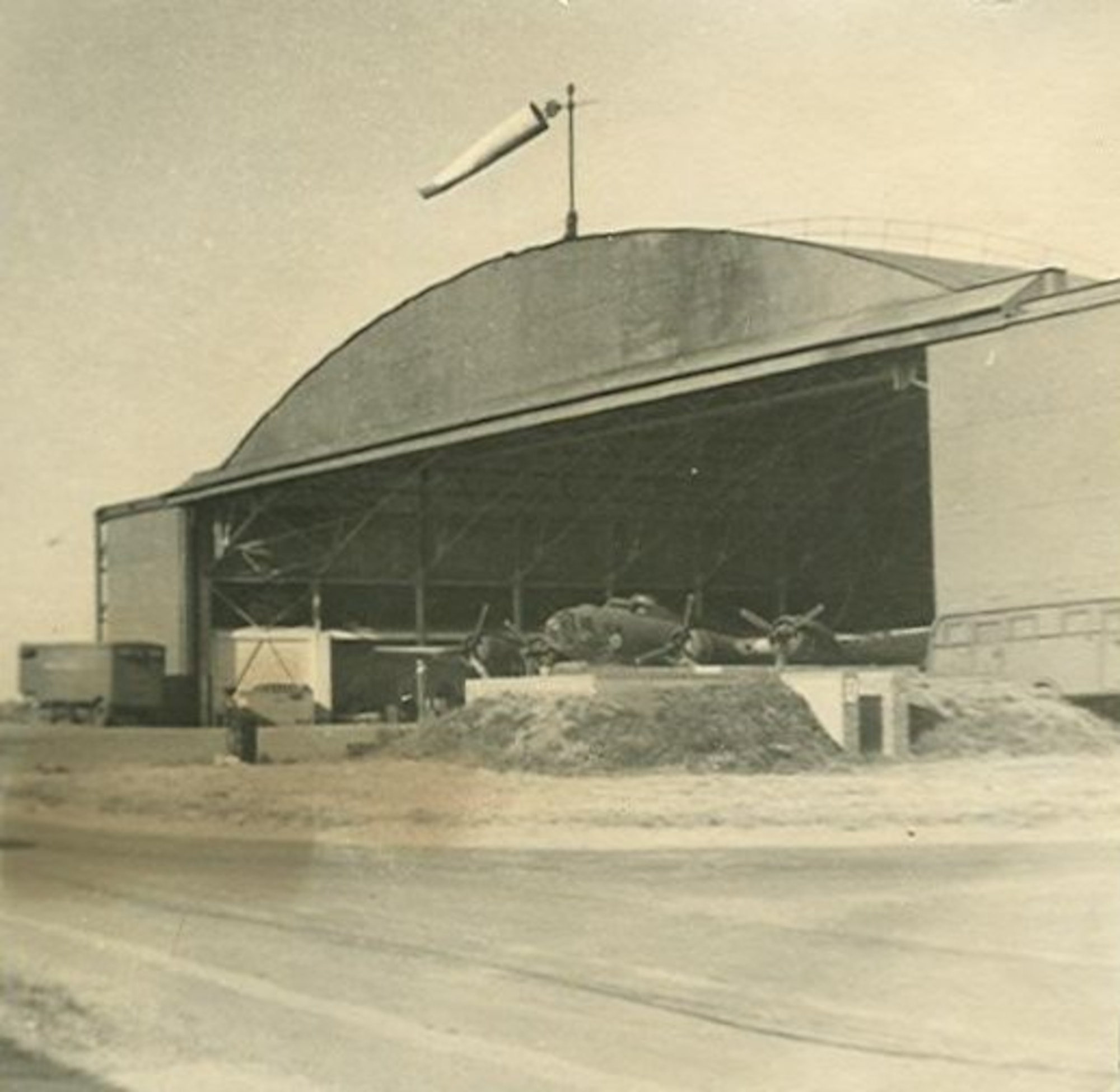The aircraft repair hangar at RAF Molewworth, England which was accidentally bombed on July 4th, 1944.  The hangar still stands today and serves as the temporary home of the Intelligence Fusion Centre in support of NATO at RAF Molesworth, England.  An early model B17-F is shown under repair of battle damage in this 1943 photo. (Photo courtesy of the 303rd Bomb Group Association)