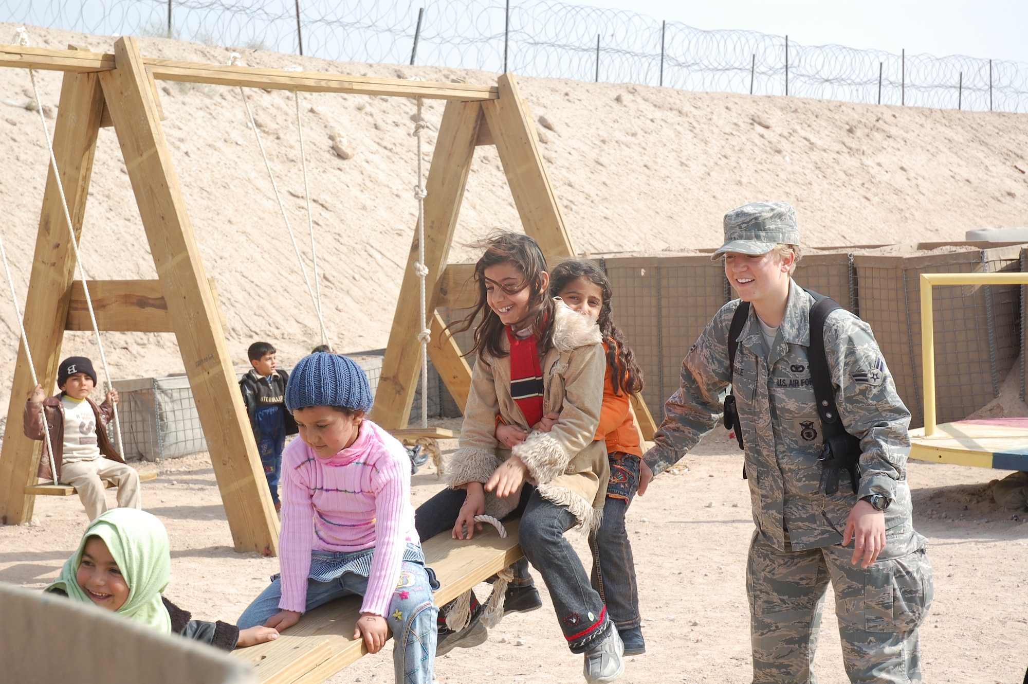 CAMP BUCCA, Iraq – Airman 1st Class Sarah Coble, 886th Expeditionary Security Forces Squadron, plays with children who are visiting family and friends detained in the Theater Internment Facility in Camp Bucca, Iraq, Feb. 10, 2008.  Airmen deployed to the 886th ESFS operate the TIF’s vigorous visitation program which houses detainees determined to be a security threat against Iraqi citizens or coalition forces. More than 1,700 friends and family members visit the detainees each week. Airman Coble is deployed from Keesler Air Force Base, Miss. (U.S. Air Force Photo/Capt. Jason McCree)